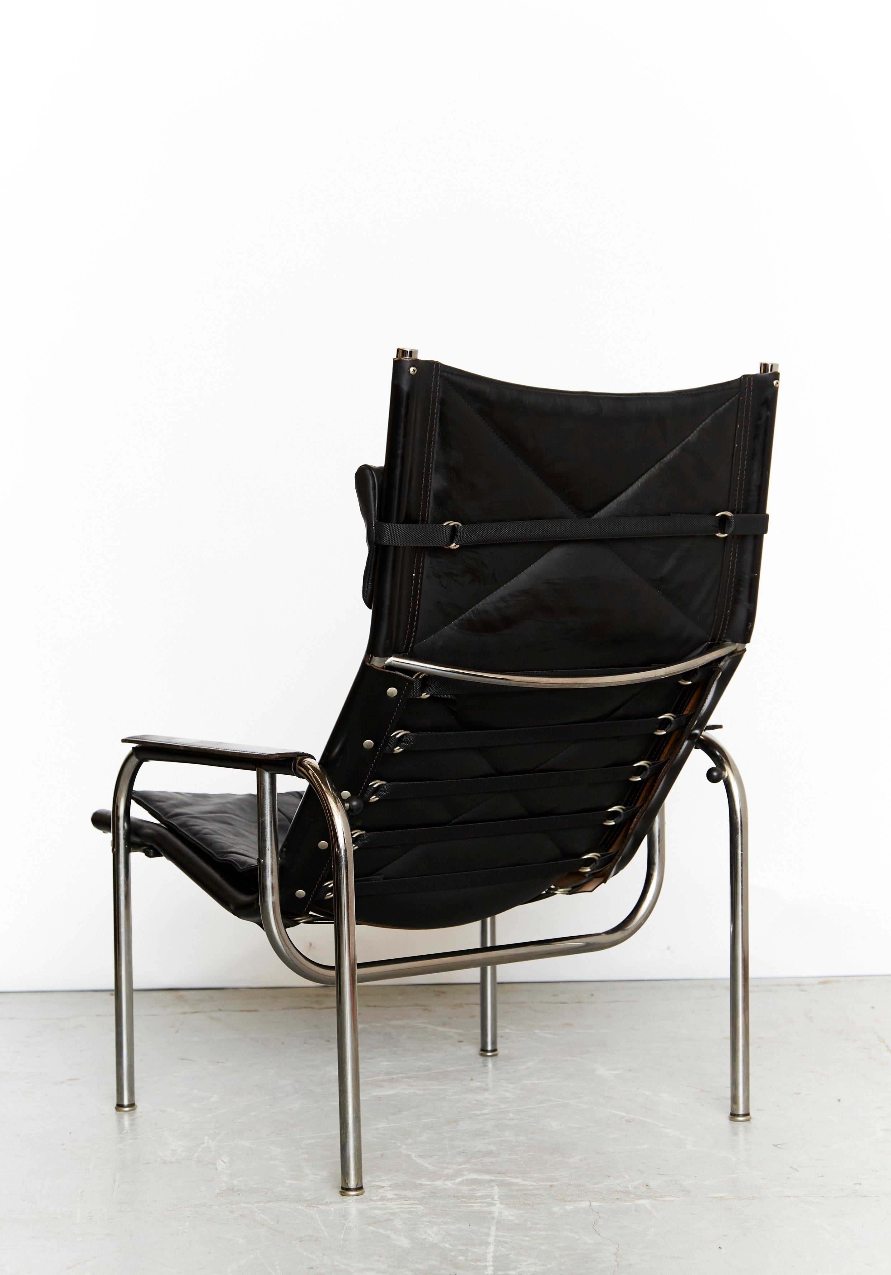 Hans Eichenberger Lounge Chair & Ottomane HE1106 for Strässle — angled view highlighting black leather and metal frame