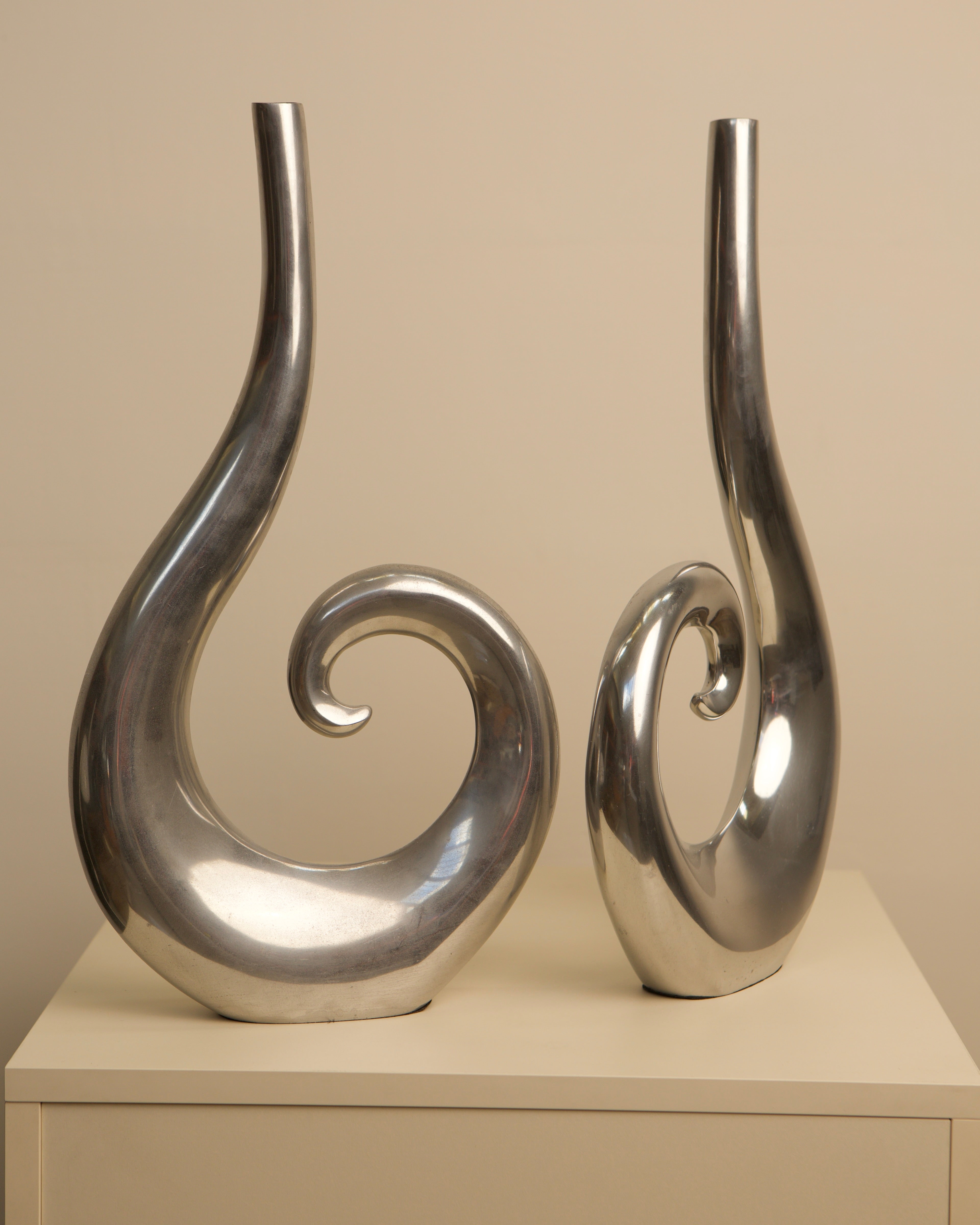 Curved aluminum vases pair showing sculptural spiral design detail