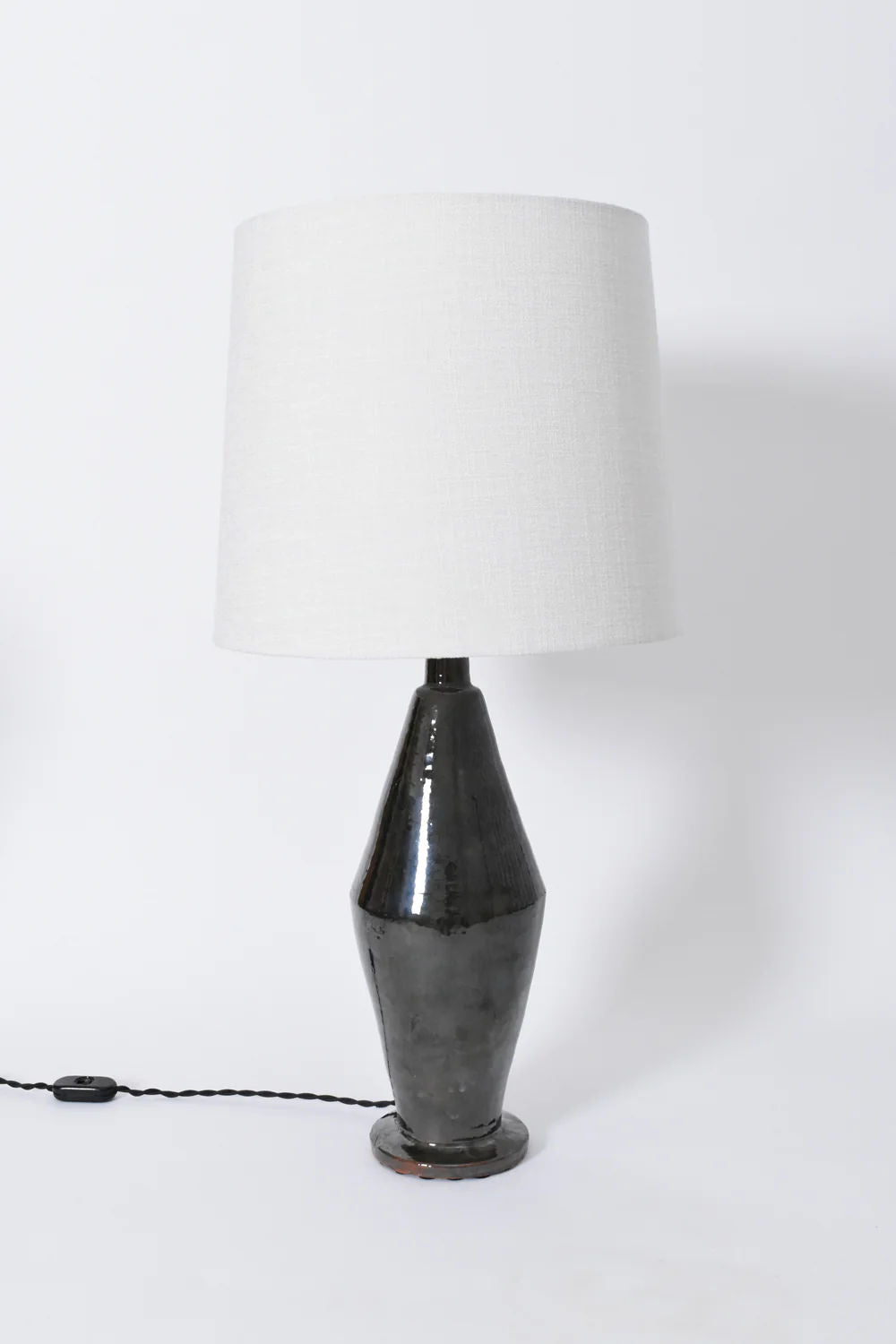 The "Arrabida" Green Table Lamp by Barracuda Interiors features a glossy green ceramic base and a large white fabric shade. Made in Portugal, it has an electrical cord with switch visible on the left against a plain white background.