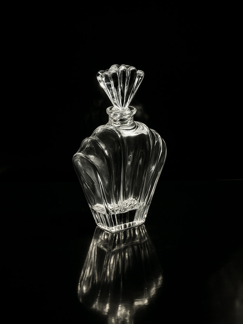 The Italian crystal Glass Art Deco Decanter by Dodo Vintage (1980s) features a sleek design with a fan-shaped stopper, showcased against a black background with light highlighting its curves.