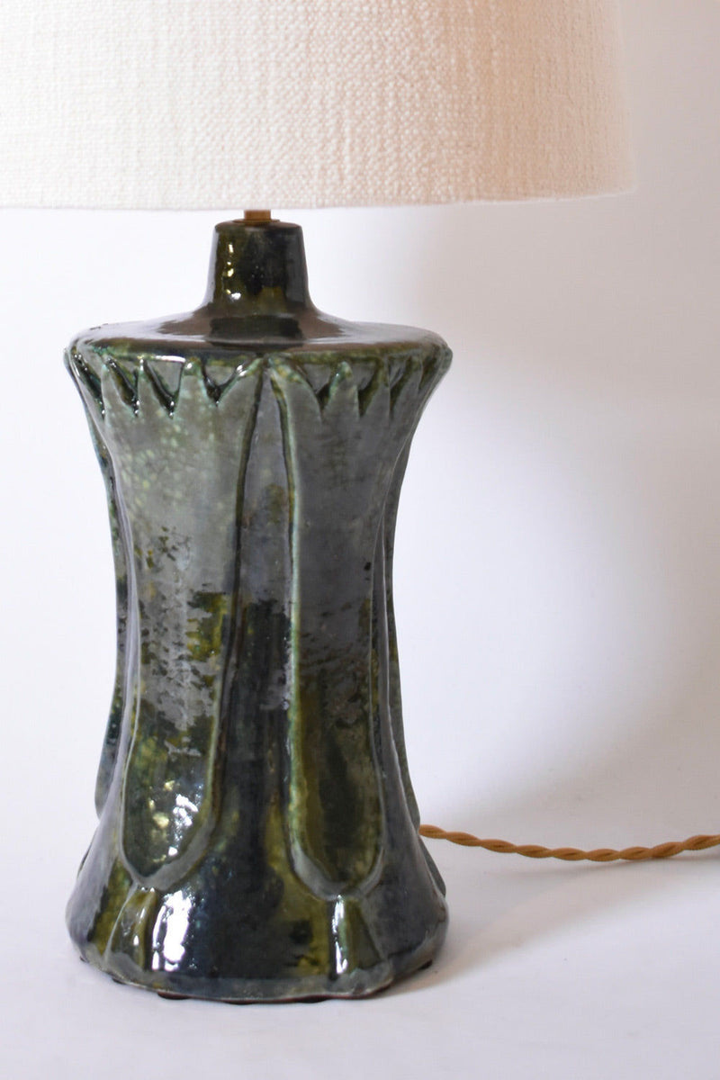 The "Kasaï" Blue Green Papyrus Ceramic Lamp by Barracuda Interiors features a glossy, textured ceramic base with vertical ridges and a large light beige fabric shade, complemented by a twisted cord.