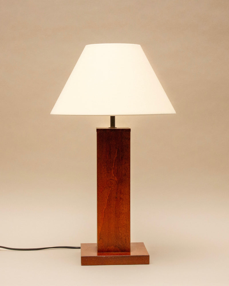 The SÒLER Almeria Table Lamp, with a vintage wooden rectangular base, cream shade, and visible black power cord, stands on a neutral background.