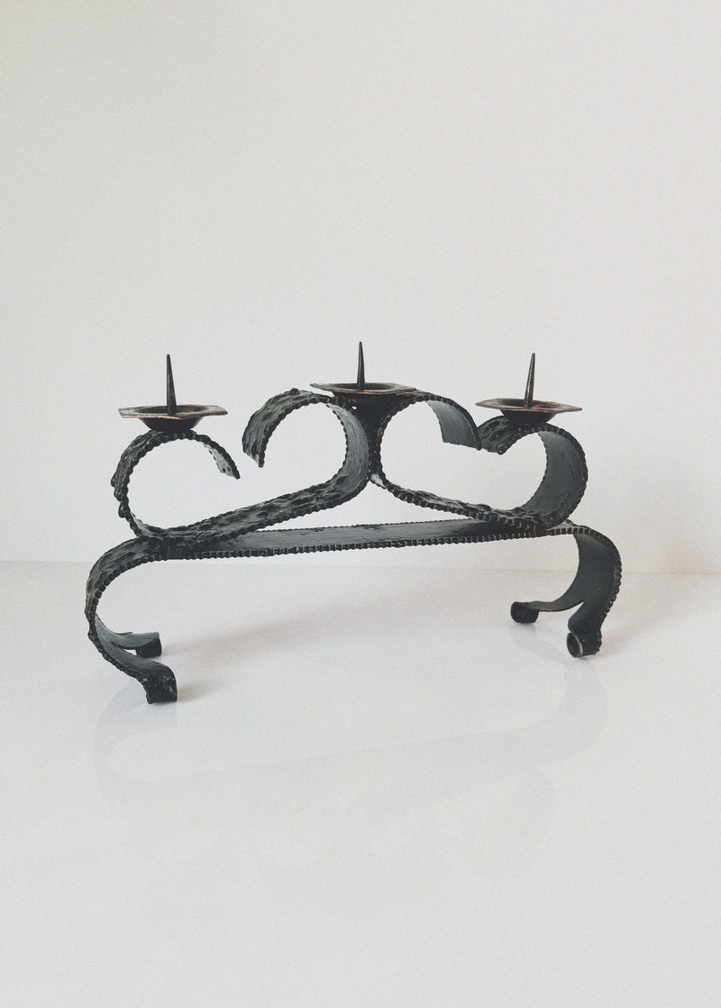 Three-candle wrought iron candleholder with curved serpentine design