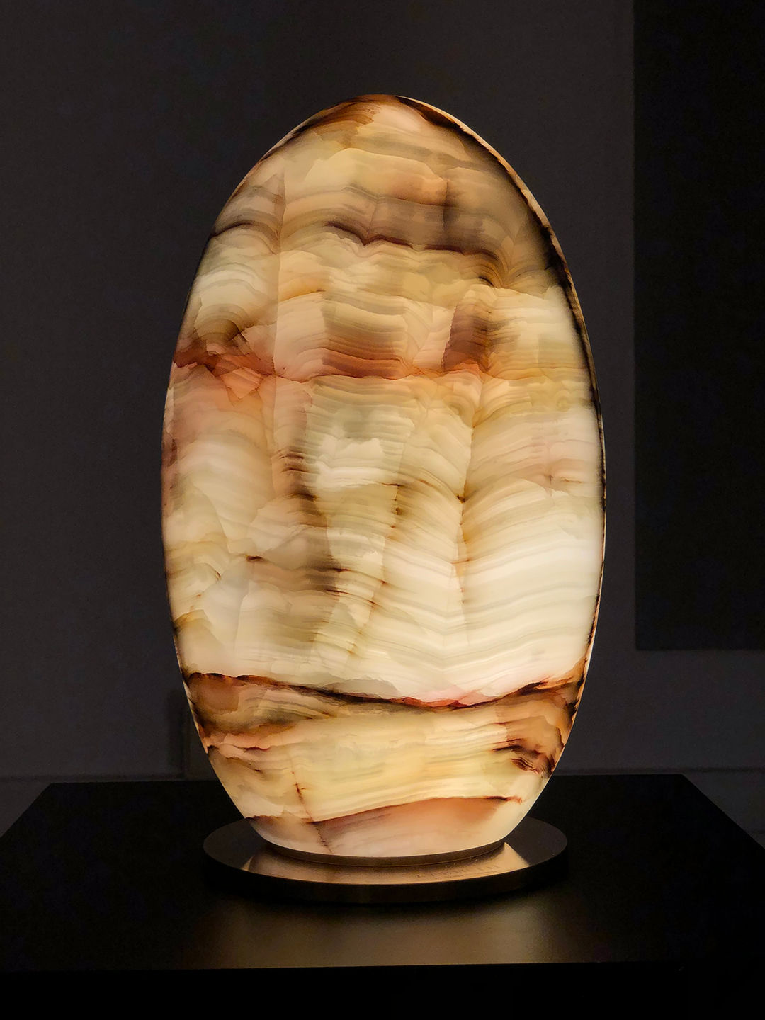 Rebirth' Table Lamp by Giulia Archimede — illuminated on dark surface in gallery setting