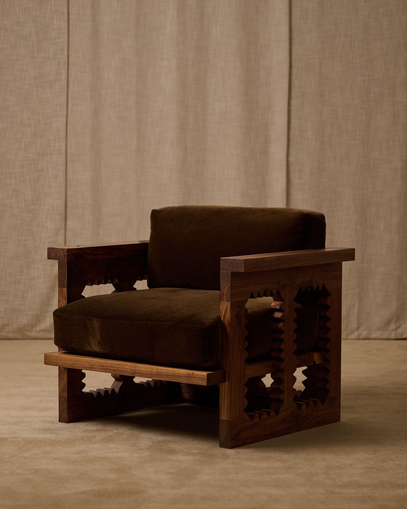Jura wooden club chair with geometric cutout design and olive cushions