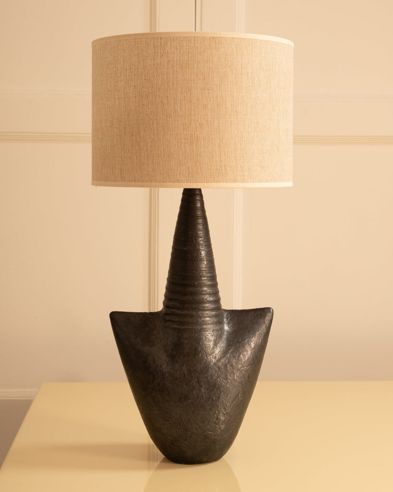 Dark stoneware table lamp with textured ceramic base and linen shade