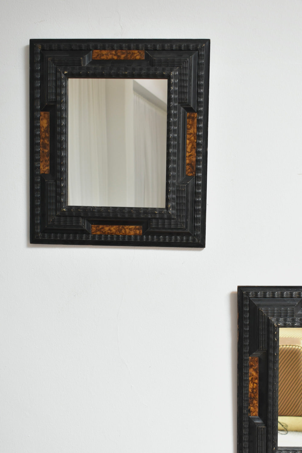 Pair of carved ebonised wood and trompe l'oeil turshell mirrors, XIXth c. — detail view