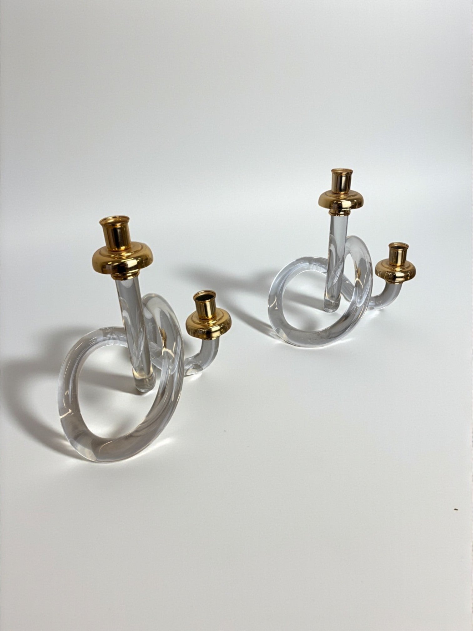 Pair of Pretzel Candleholders by Dorothy Thorpe, Circa 1970 — clear glass with gold accents on white background