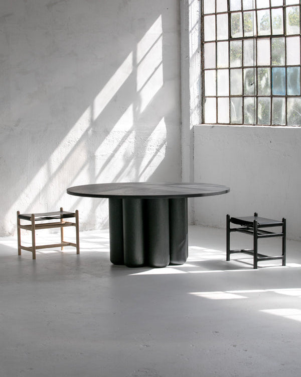 Ina Dining Table in Solid Wood — close-up of round black tabletop in studio setting