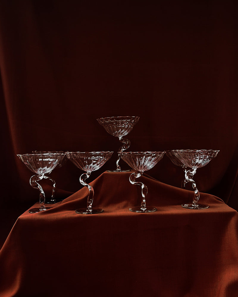 Crystal Ribbon cocktail coupes with twisted stems on burgundy silk