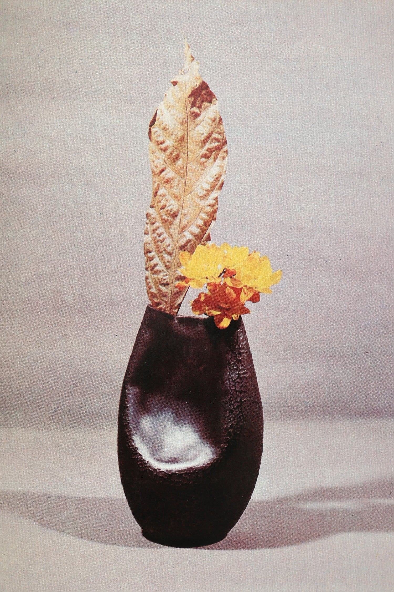 Creative Ikebana Book — close-up of dark ceramic vase with flowers