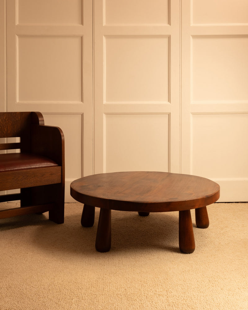 French wooden coffee table with chunky legs on beige carpet