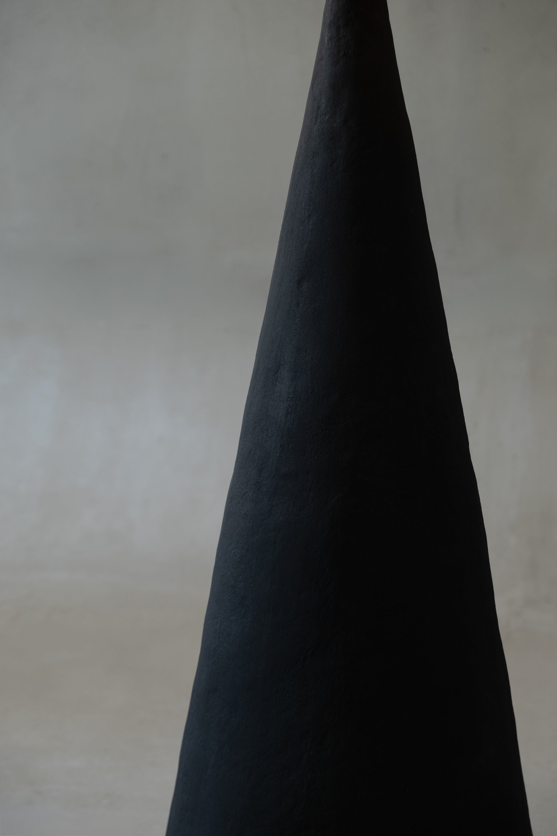 VERETENO Floor Lamp — close-up of dark textured surface in minimalist setting