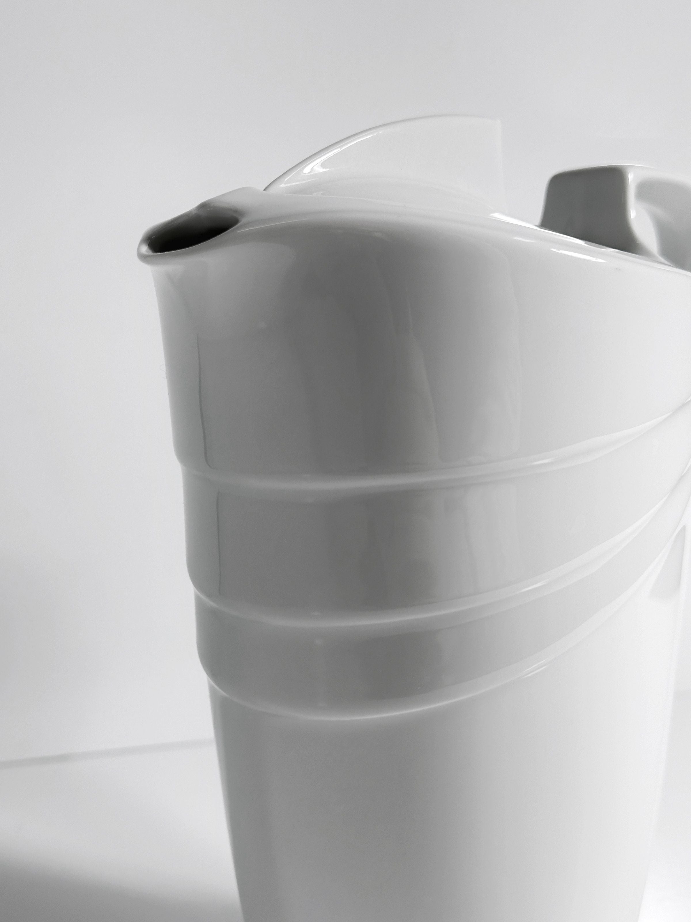 White porcelain Art Deco pitcher with ribbed bands, close-up view
