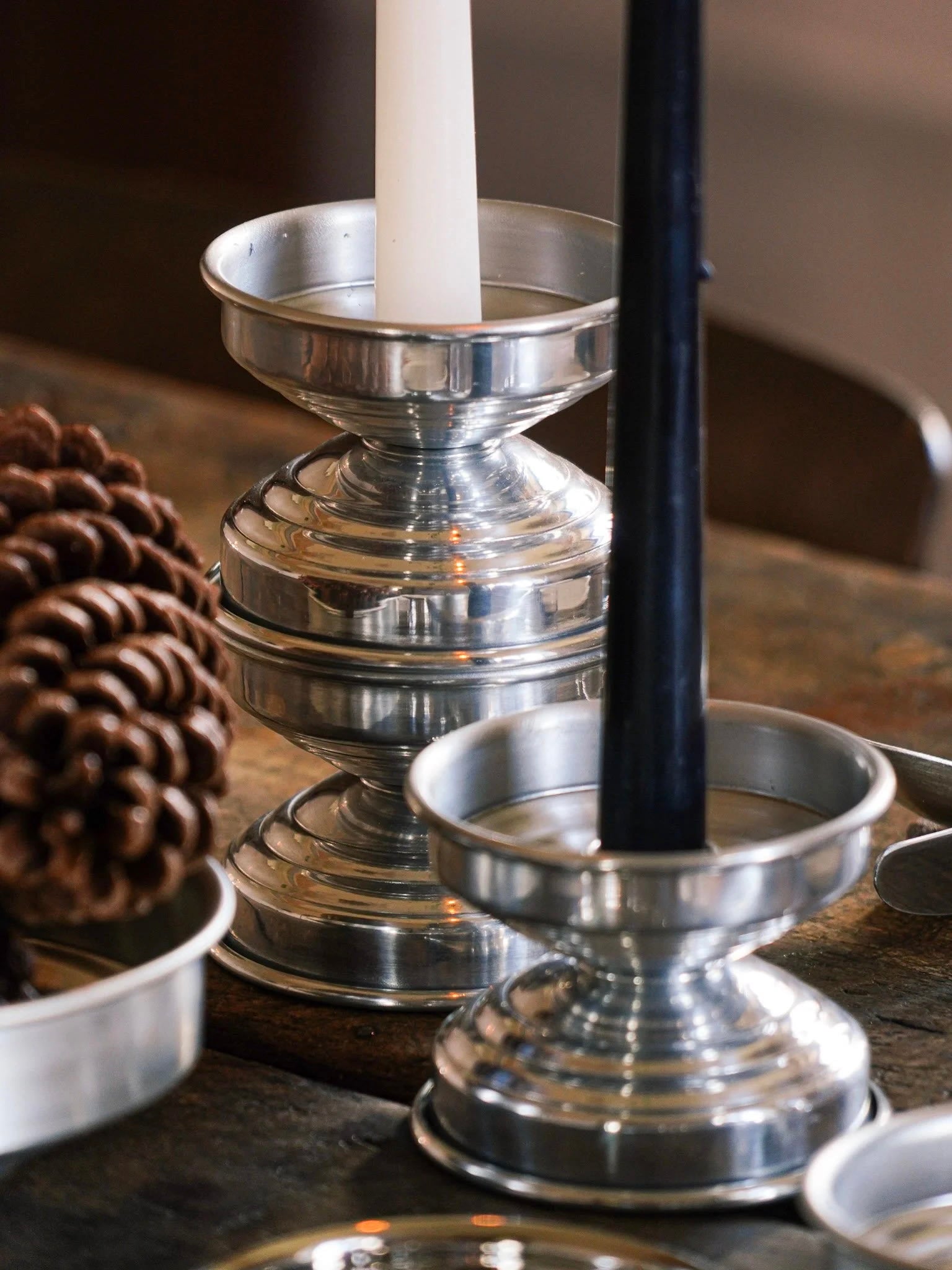Polished Metal Candle Holders in Polished aluminum — side angle on rustic wooden table