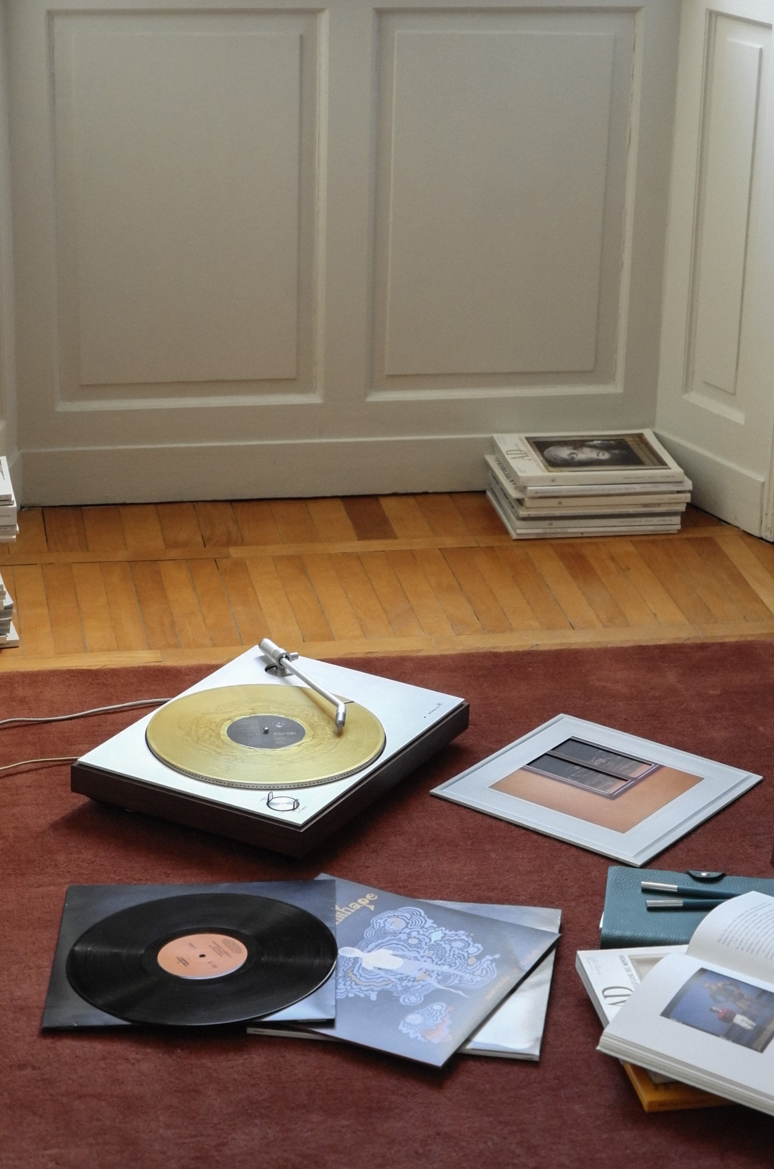 Hand-woven Rug in New Zealand Wool, Rouille — side angle with vinyl records and books