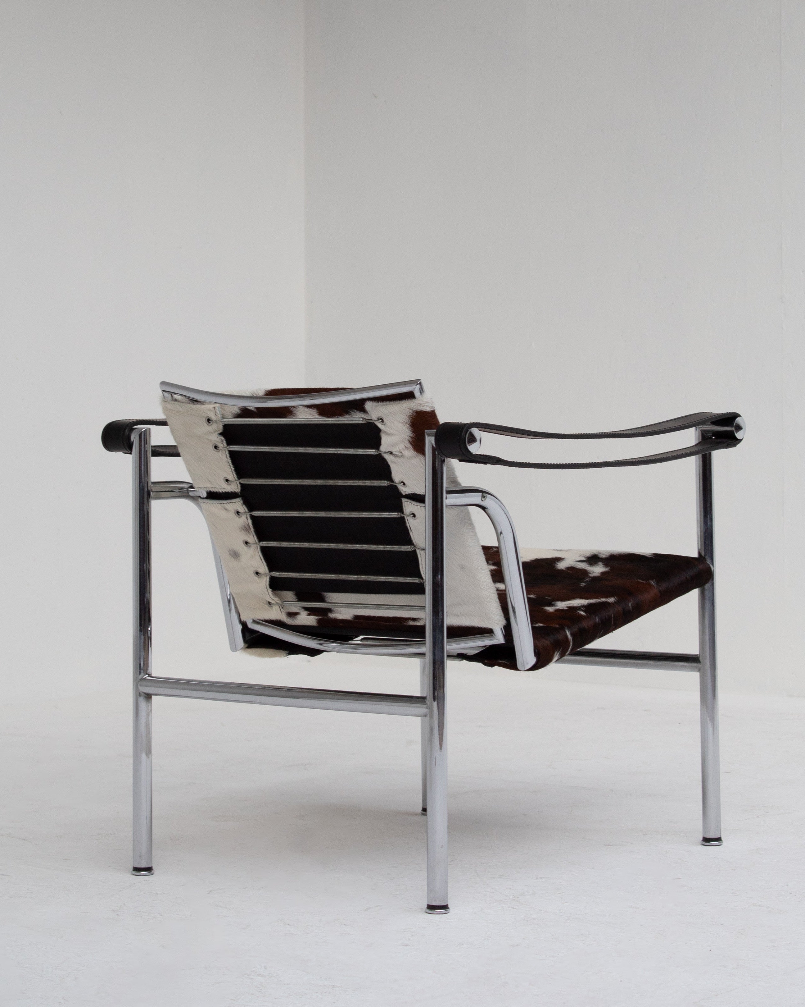 LC1 armchair profile view showing chrome frame and cowhide seat