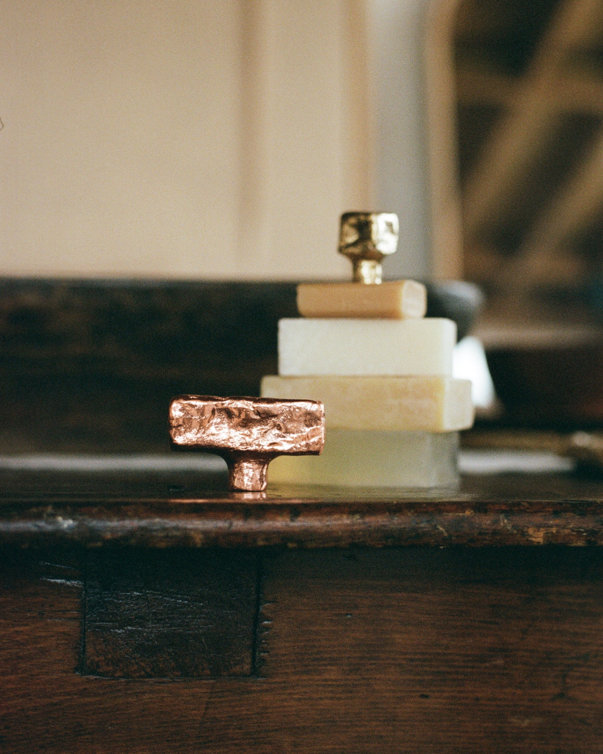 ISLE Cabinet Knob/Wall Hook Small — close-up of copper and brass on stacked soap bars