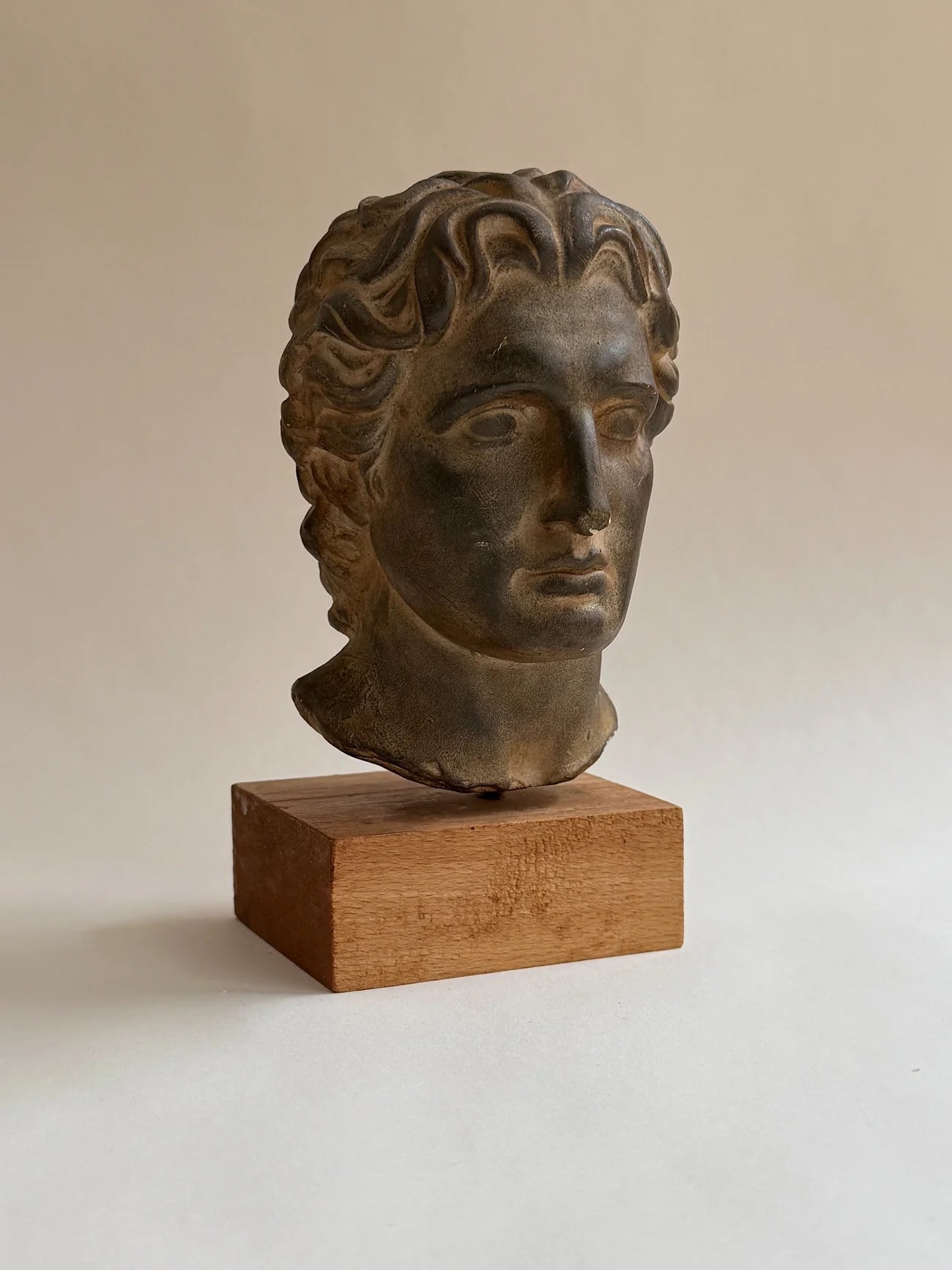 Sculptural Bust on Wooden Plinth — angled view on neutral background