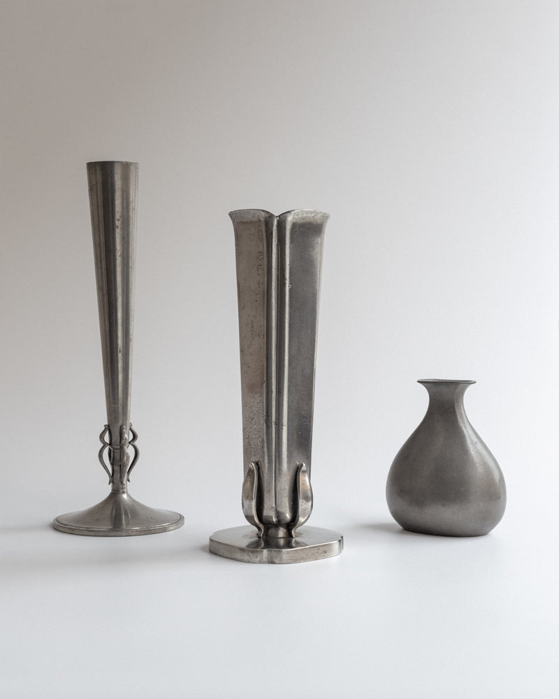 Swedish modernist pewter vase by GAB alongside decorative vessels
