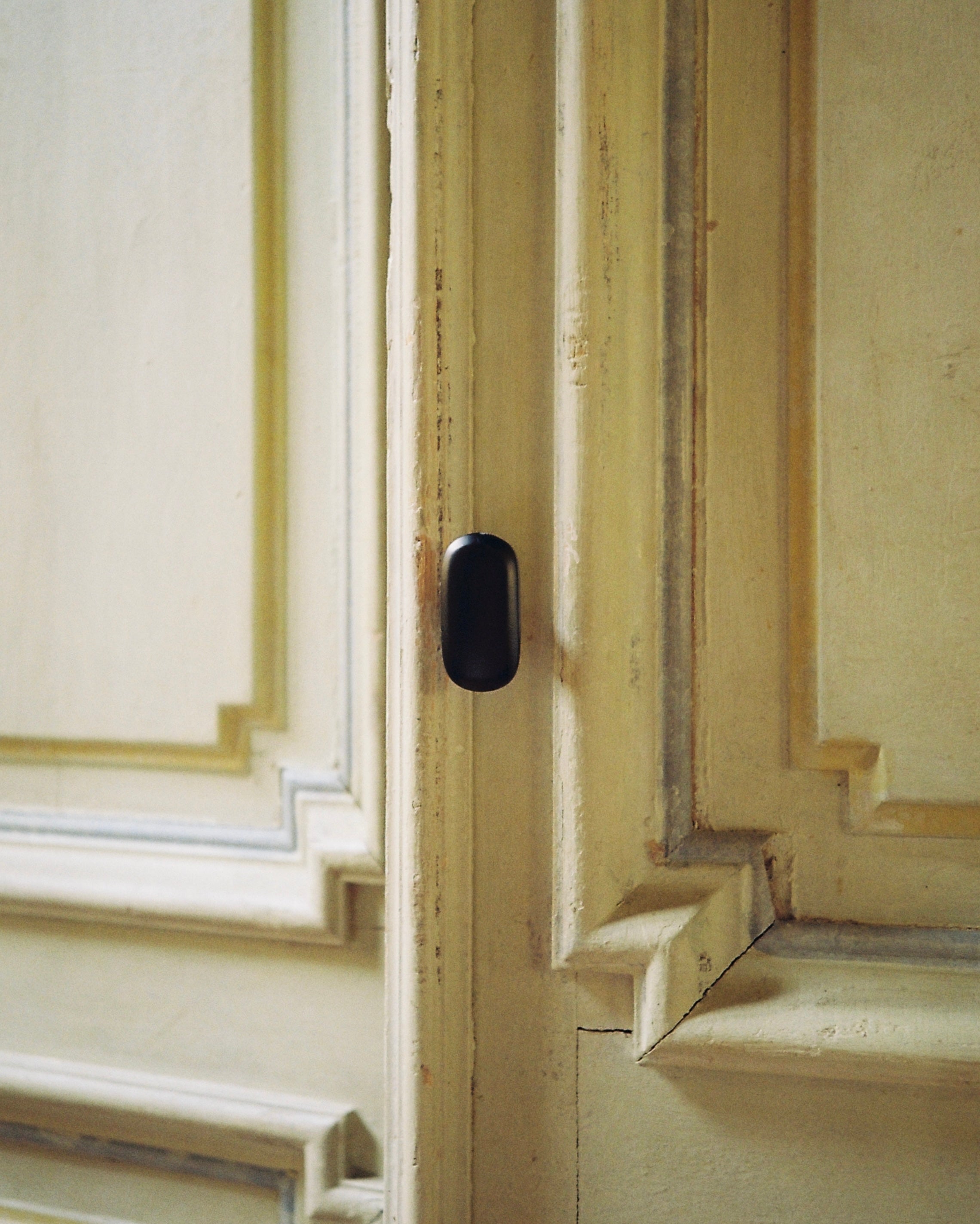 OVAL Cabinet Knob/Wall Hook — close-up of matte black finish on cabinet door