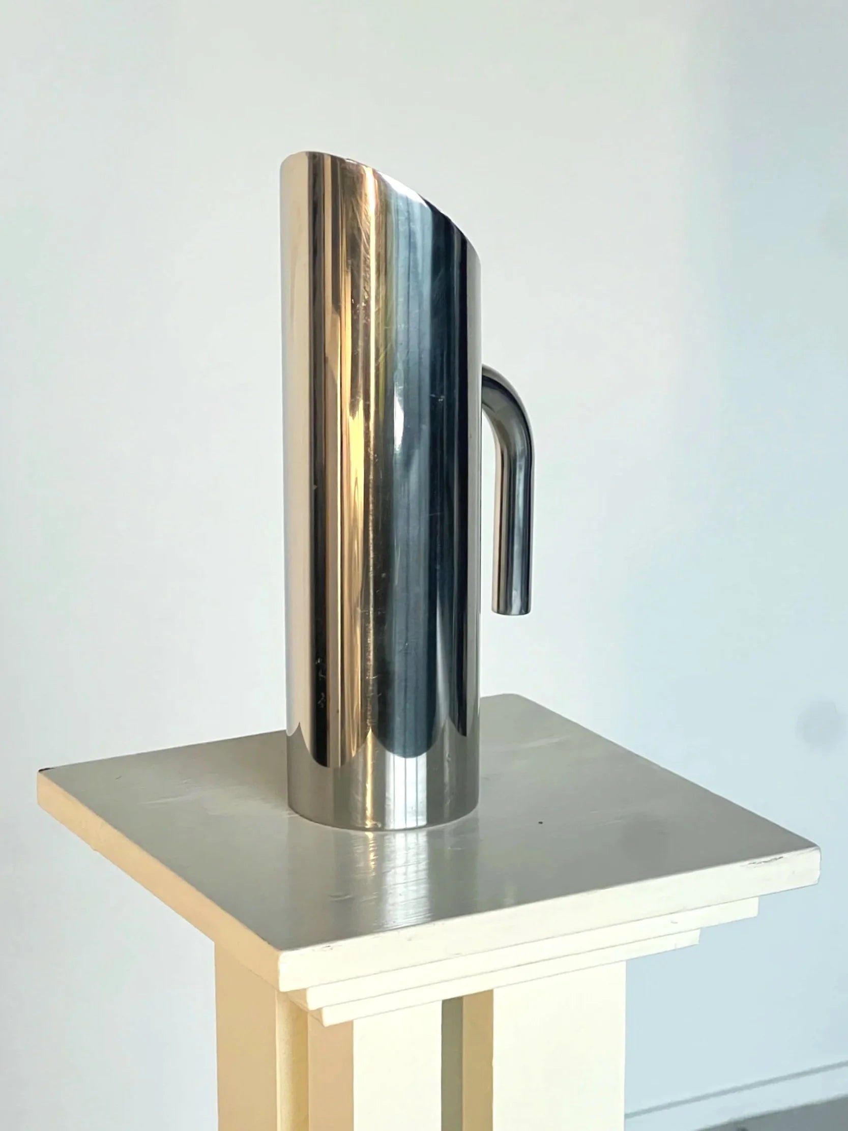 Sculptural Polished Water Jug — side angle on minimalist pedestal