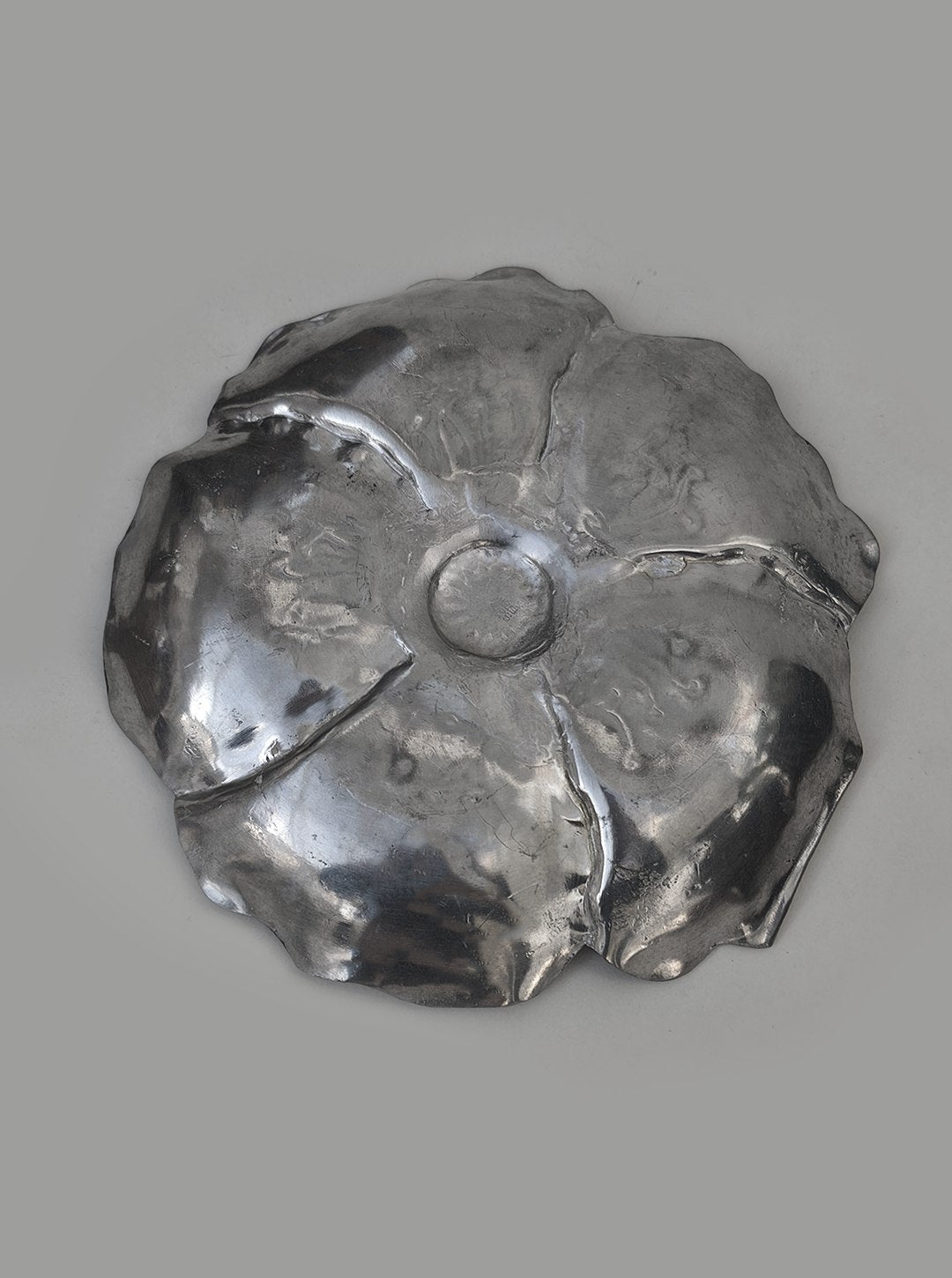 Flower pewter vide poche — overhead view on gray background