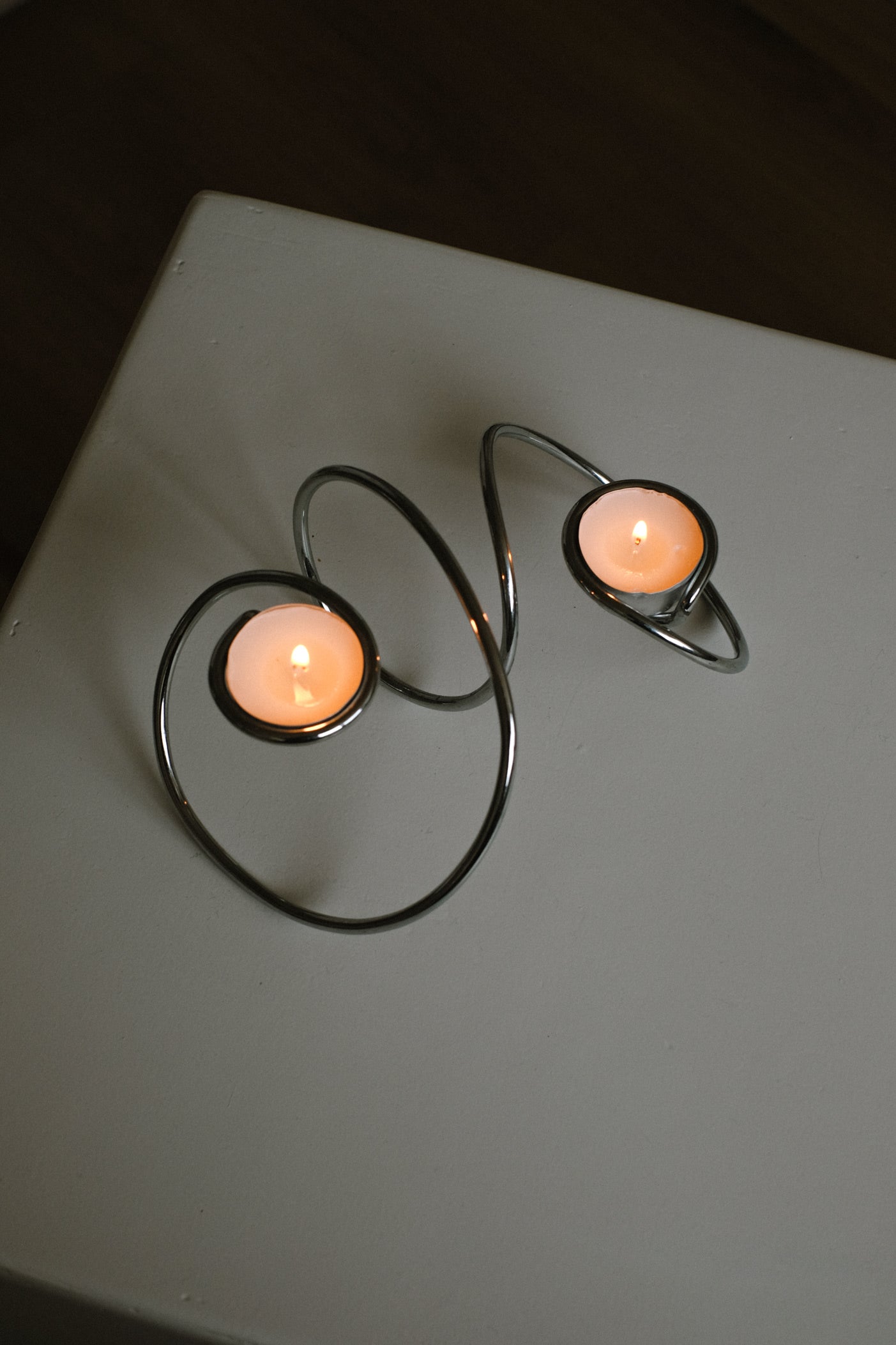 Chrome Candleholder — side view on white surface with two candles