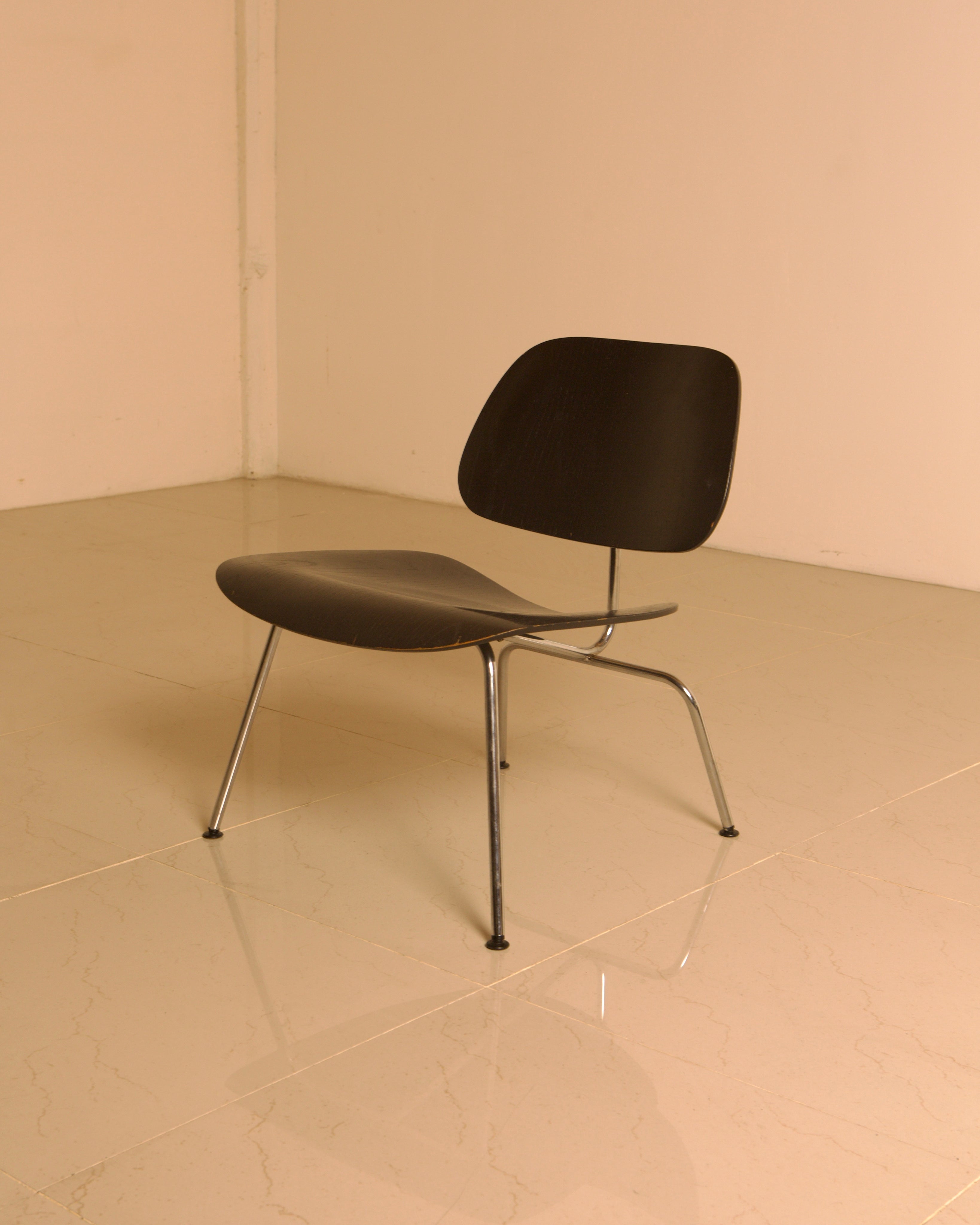 LCM Chairs by Charles and Ray Eames for Herman Miller, 1960s — black molded seat on polished floor