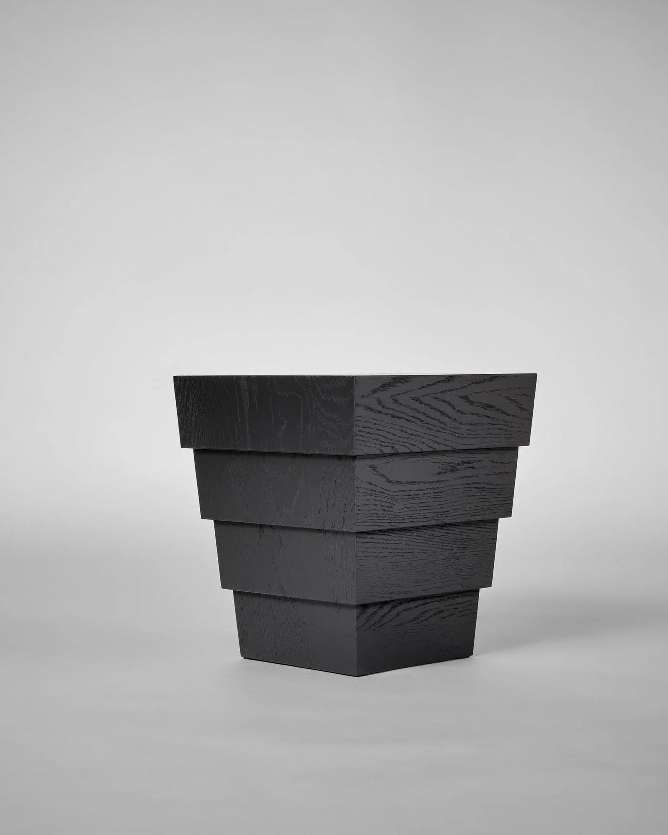 Taes Side Table — angled view of black wooden layers