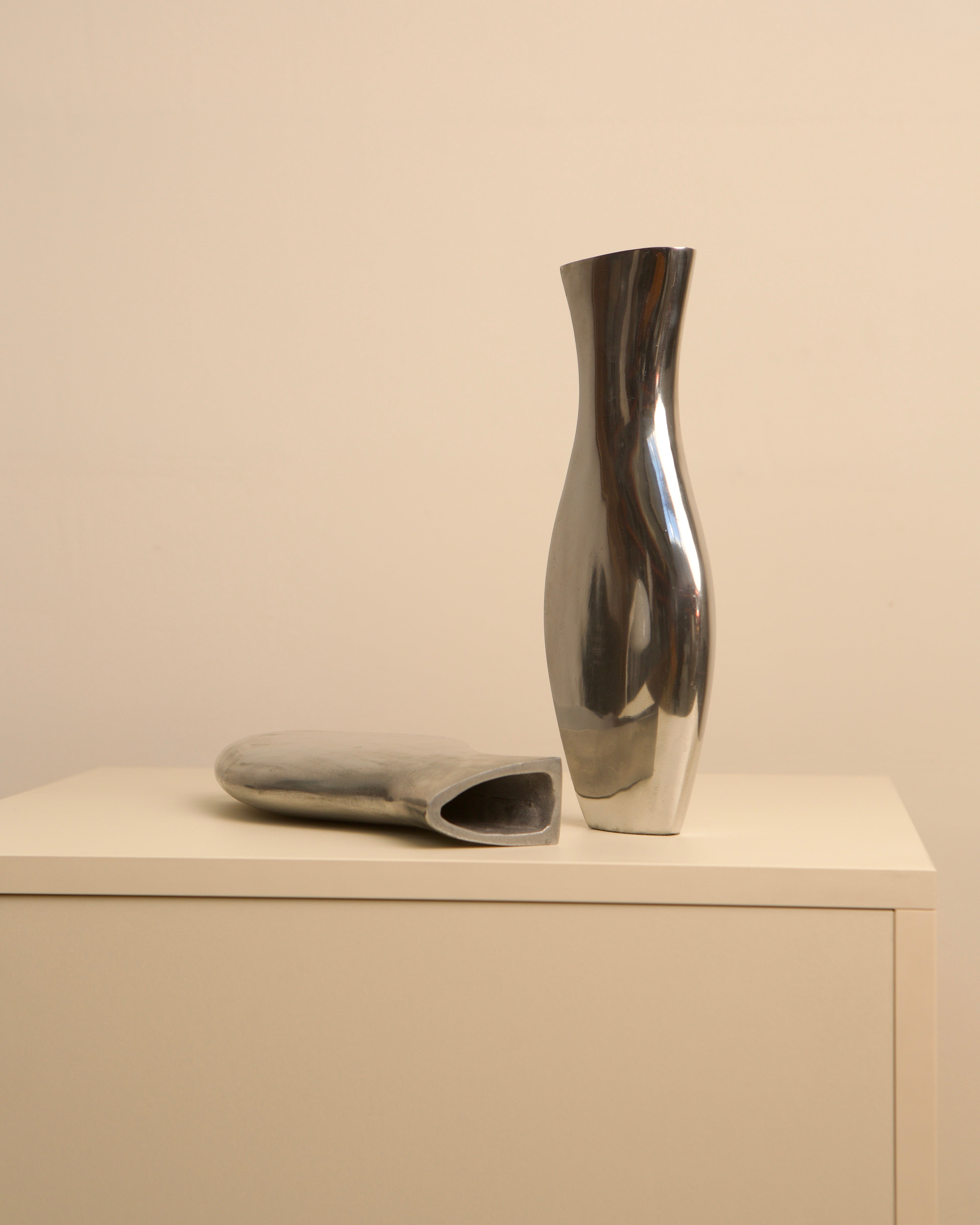 Italian cast aluminum Dame vases on minimalist shelf display