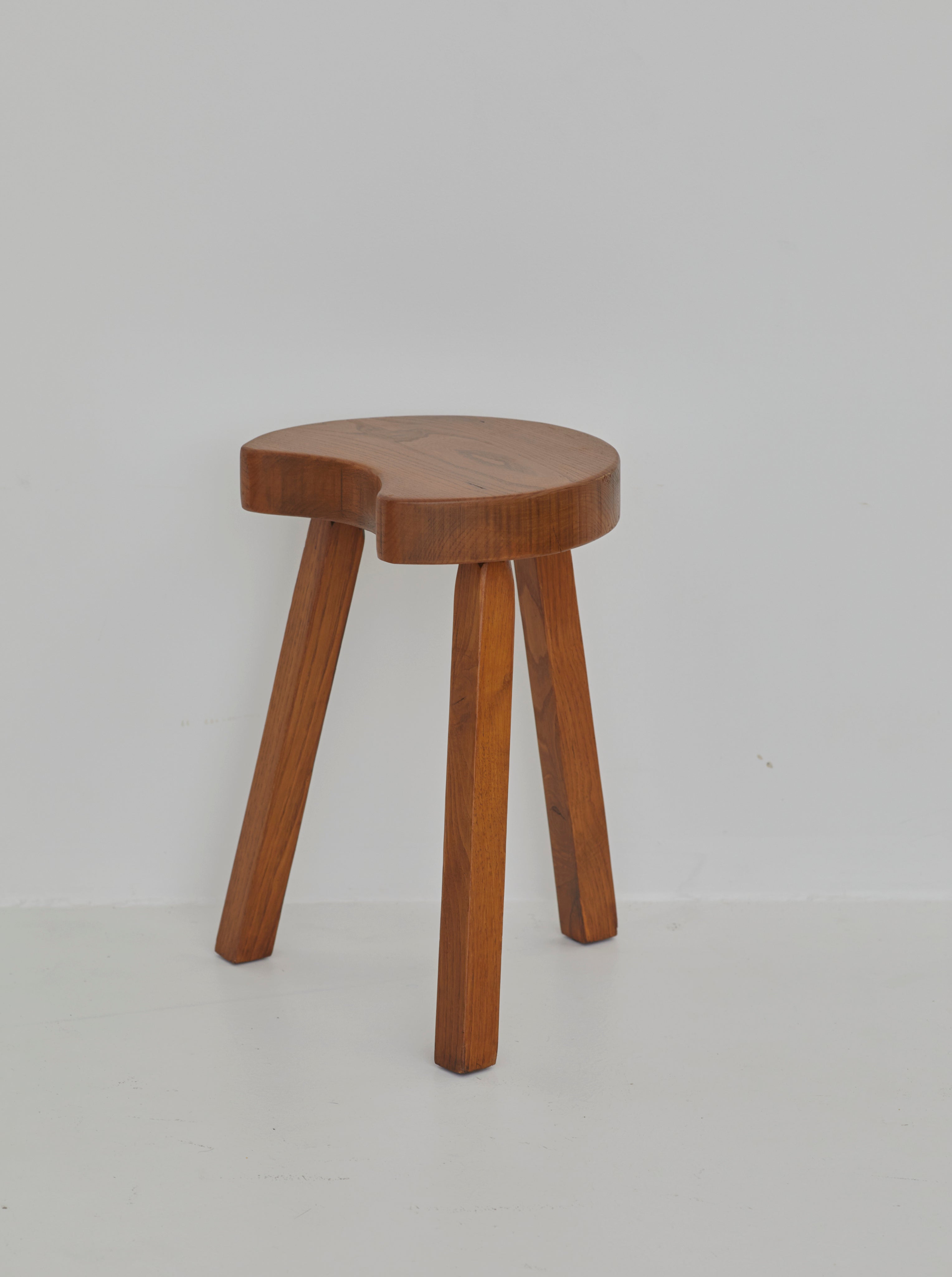 Vintage French handcrafted tripod stool in brutalist style, solid beech wood C. 1960 — side view against white background