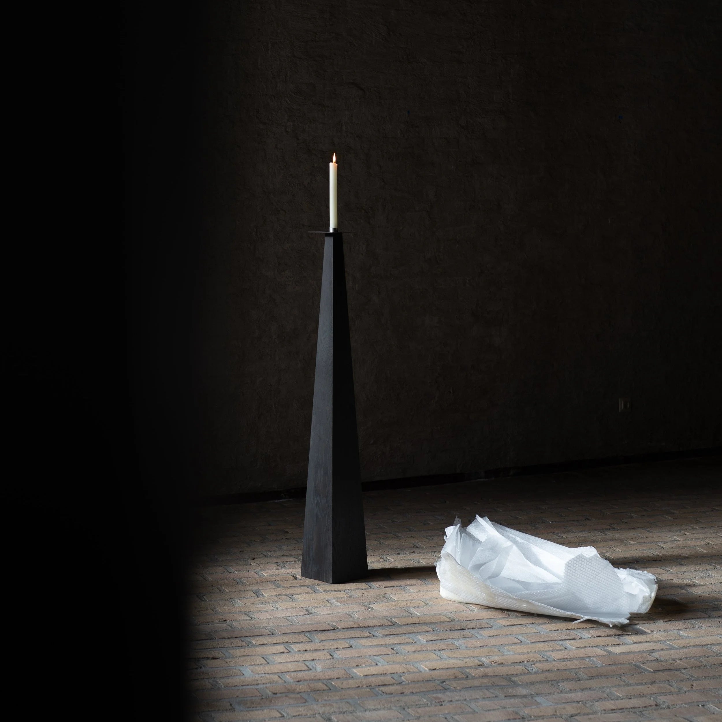Taes Candle Holder — side view of black wooden design in minimalist setting