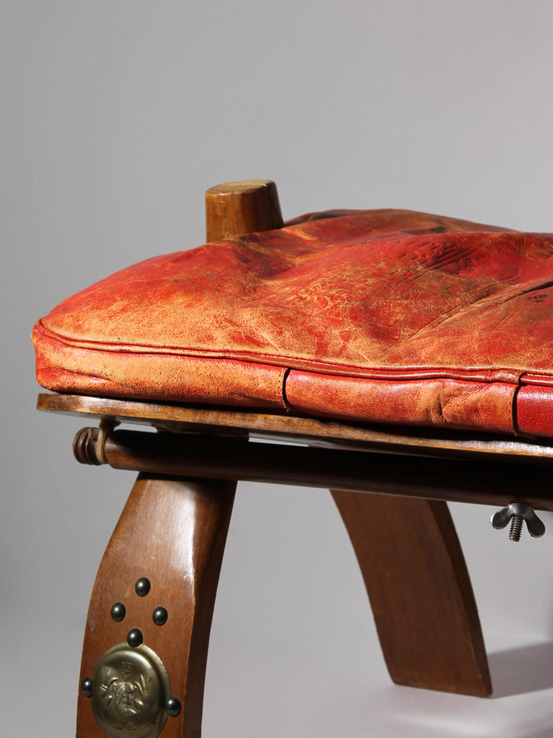 Egyptian Ottoman Camel Saddle Stool — close-up of red leather cushion and wooden legs