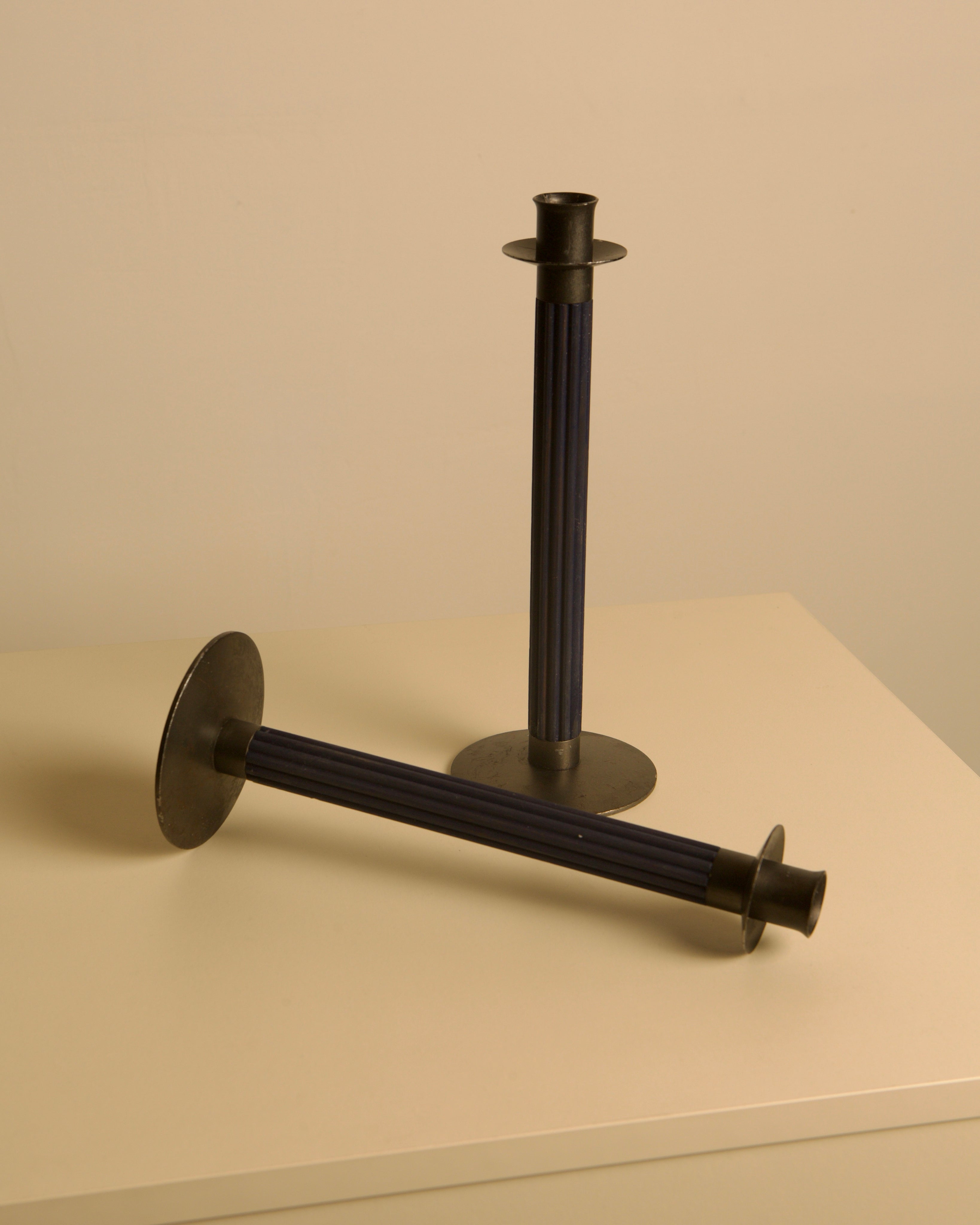 Pair of Swedish Midnight Blue Metal and Wood Candleholders c. 1960 — angled view on light surface
