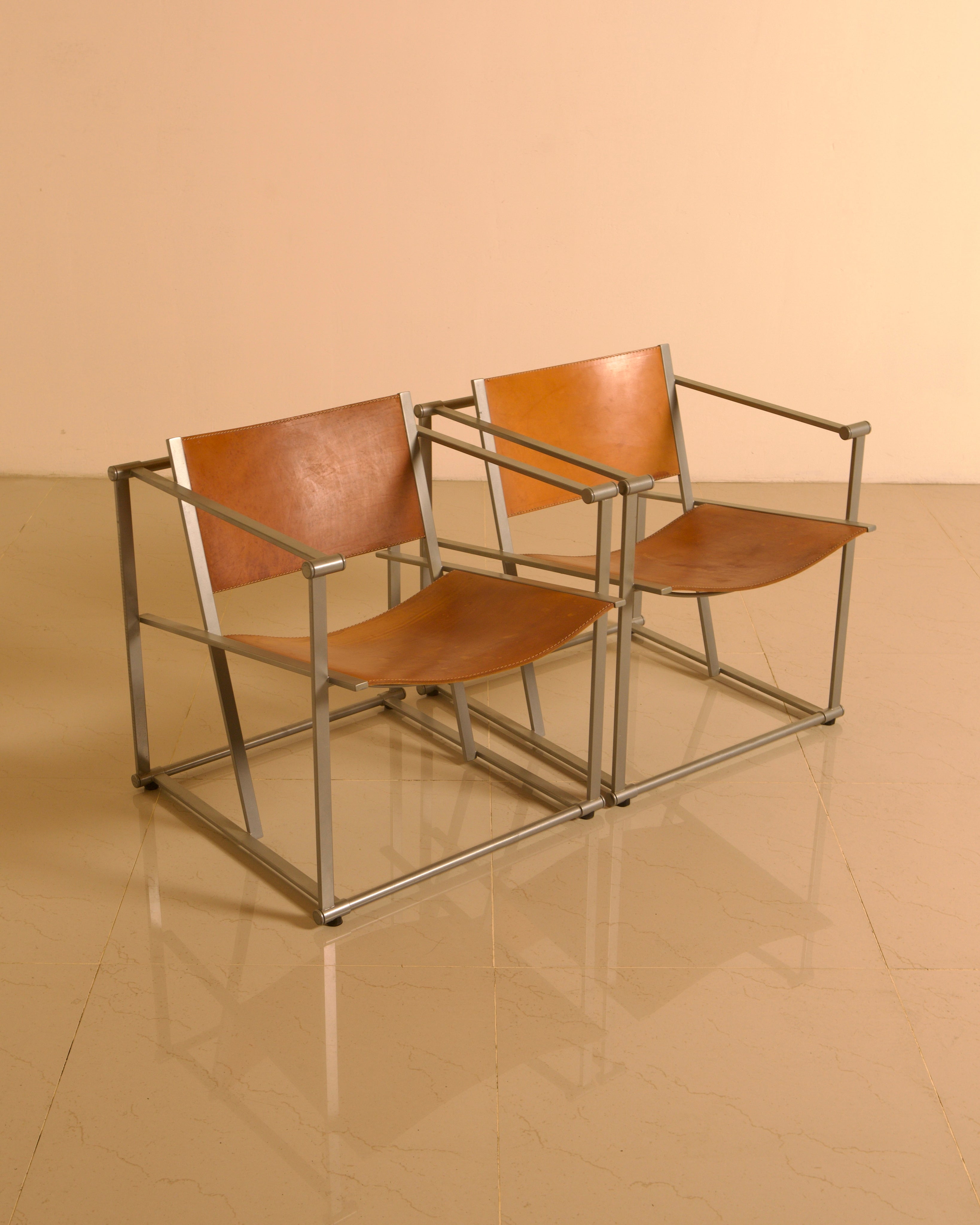 Pair of "FM62" Armchairs by Radboud van Beekum for Pastoe, 1980s — angled view on glossy floor with leather seats