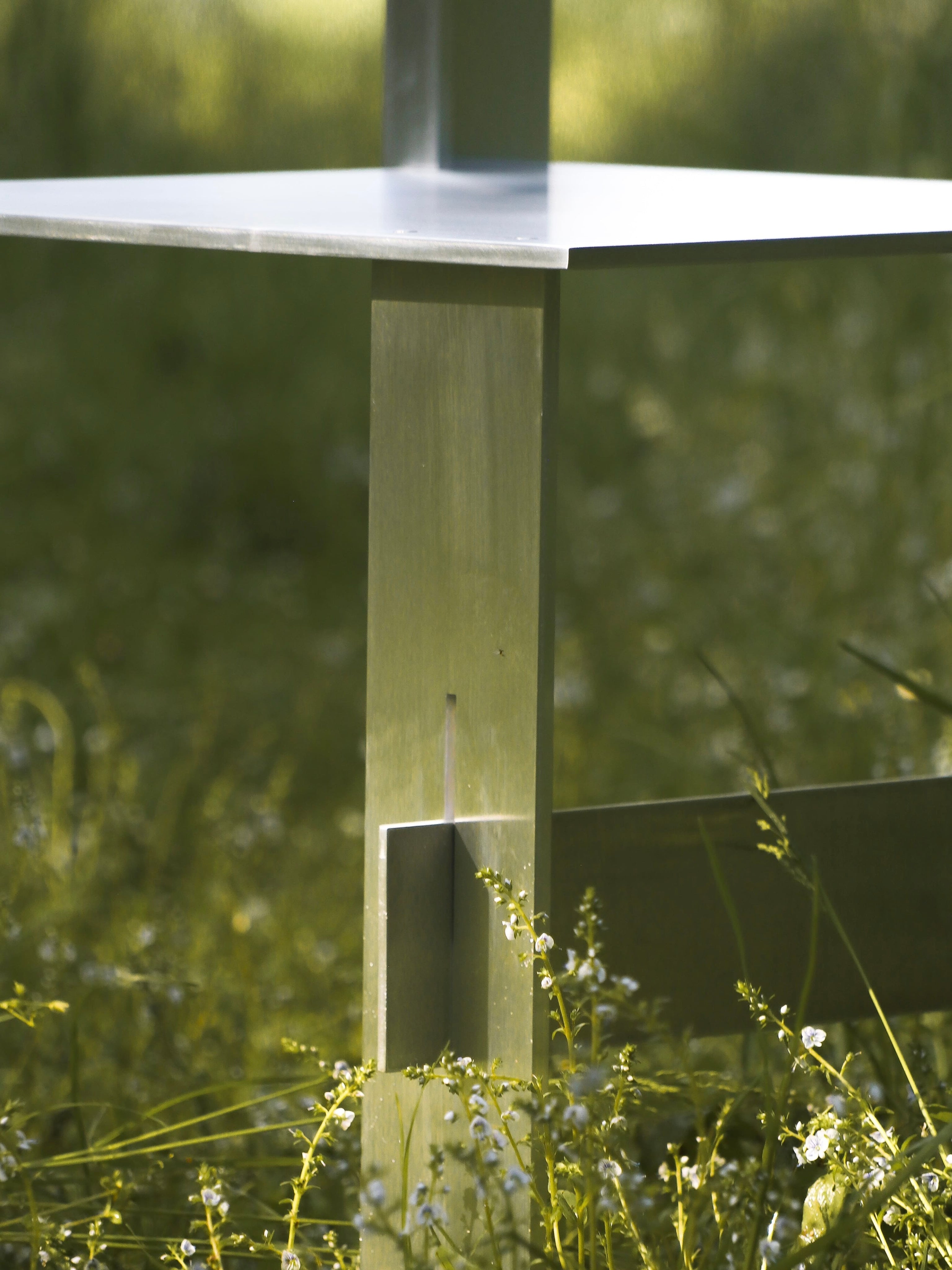 AL Chair — close-up of metal frame in grassy outdoor setting