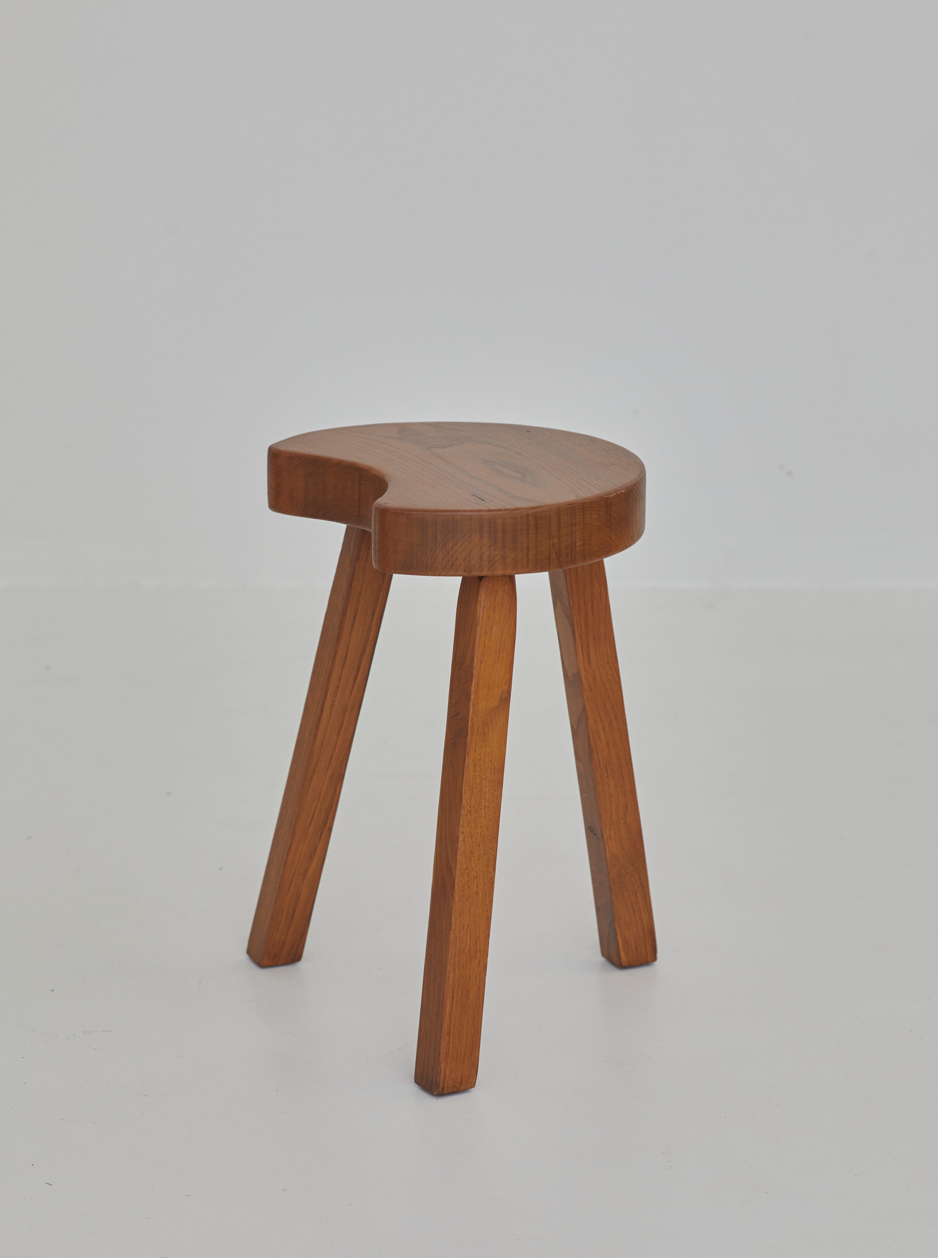 Vintage French handcrafted tripod stool in brutalist style, solid beech wood C. 1960 — angled view highlighting round wooden