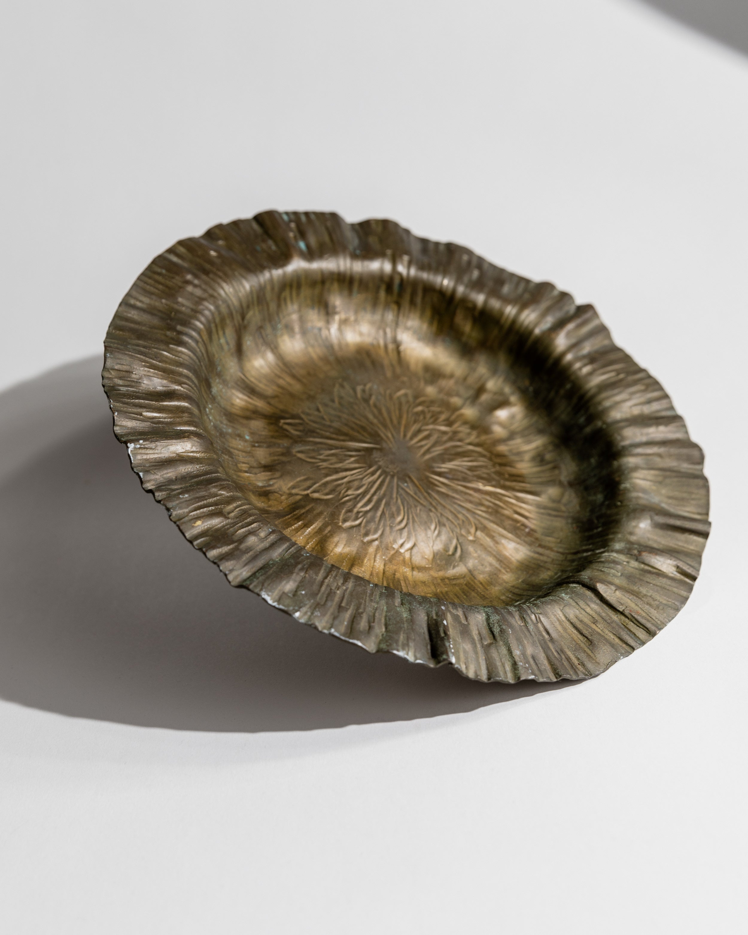 Brass bowl interior showing fluted edges and radial pattern detail