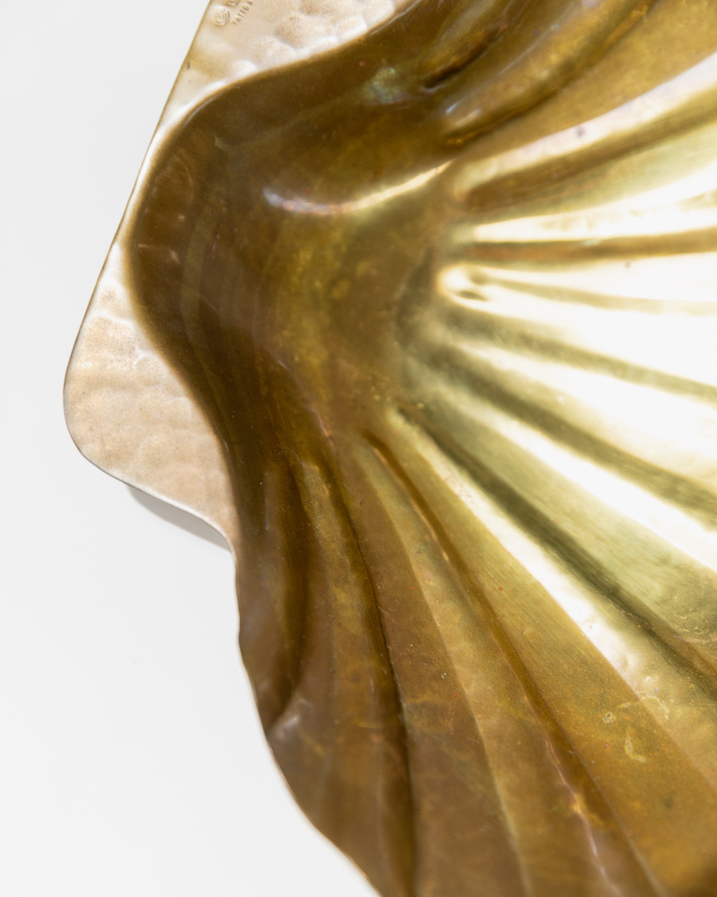 Interior detail of brass scalloped bowl showing ridged texture