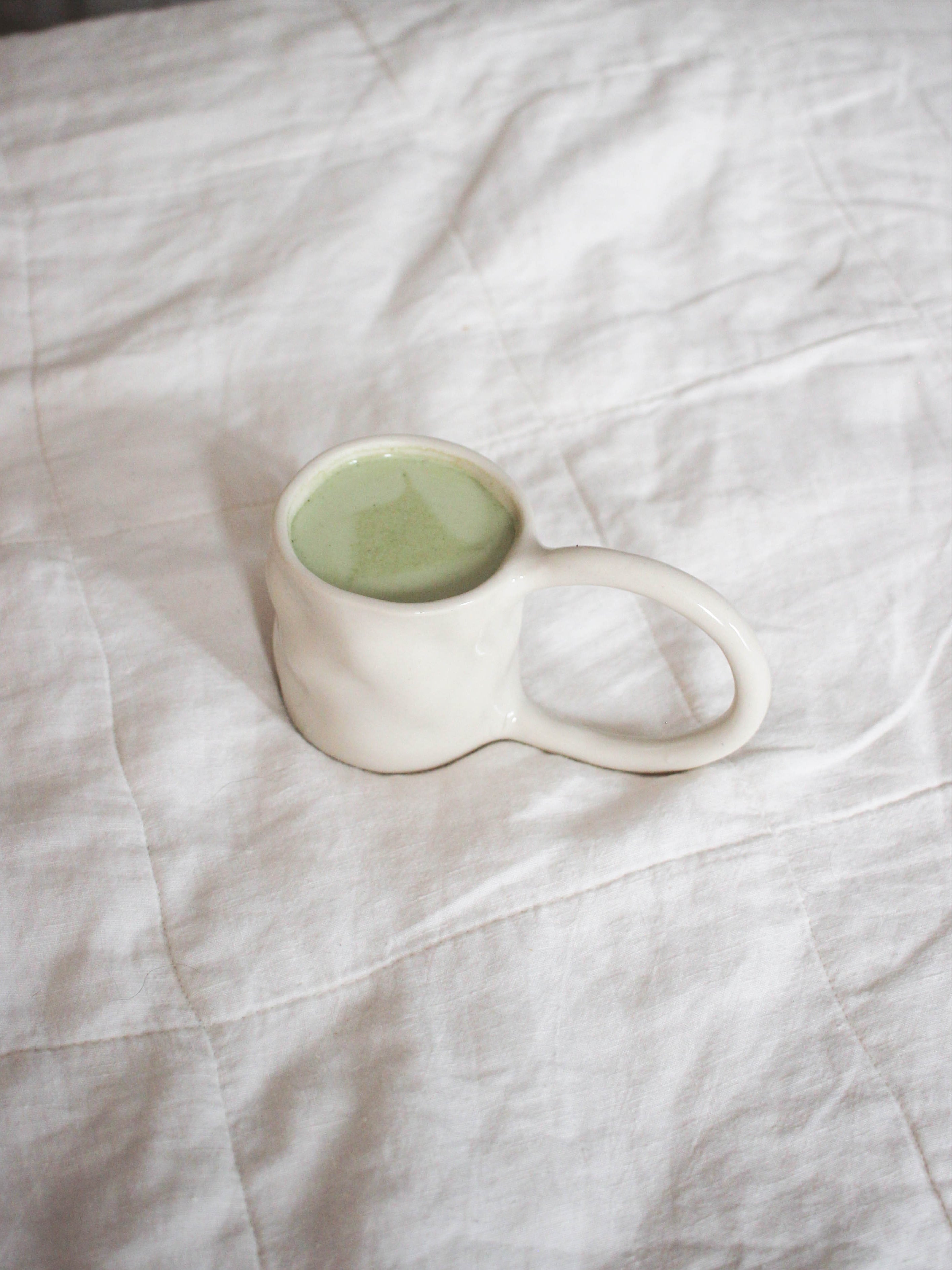 Stoneware Mugs — angled view on textured white fabric