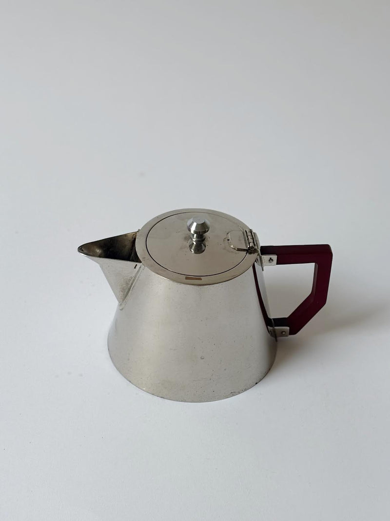 Art Deco Teapot, France — close-up of polished metal with red handle