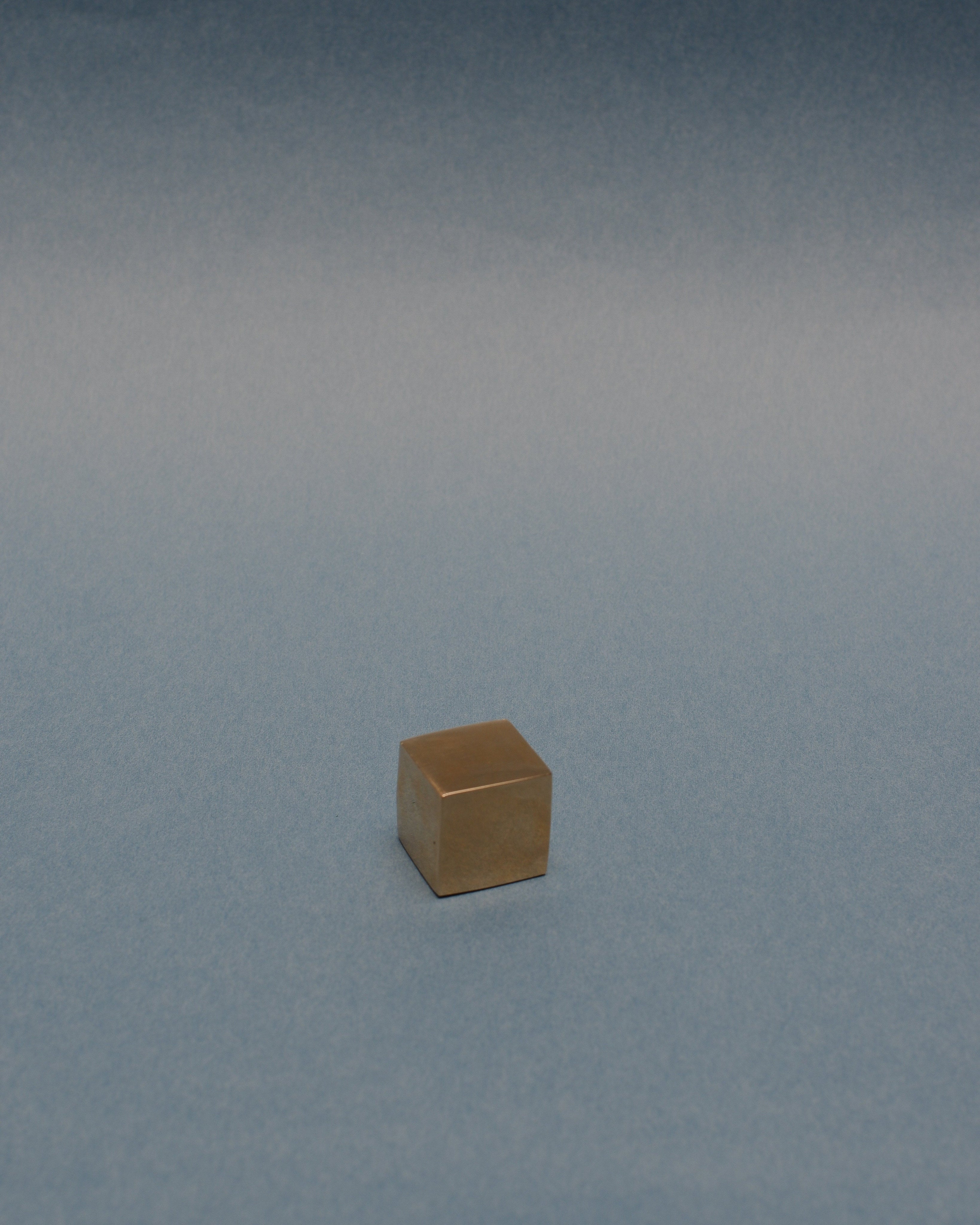 CUBE Cabinet Knob Small — close-up of brass surface on blue background