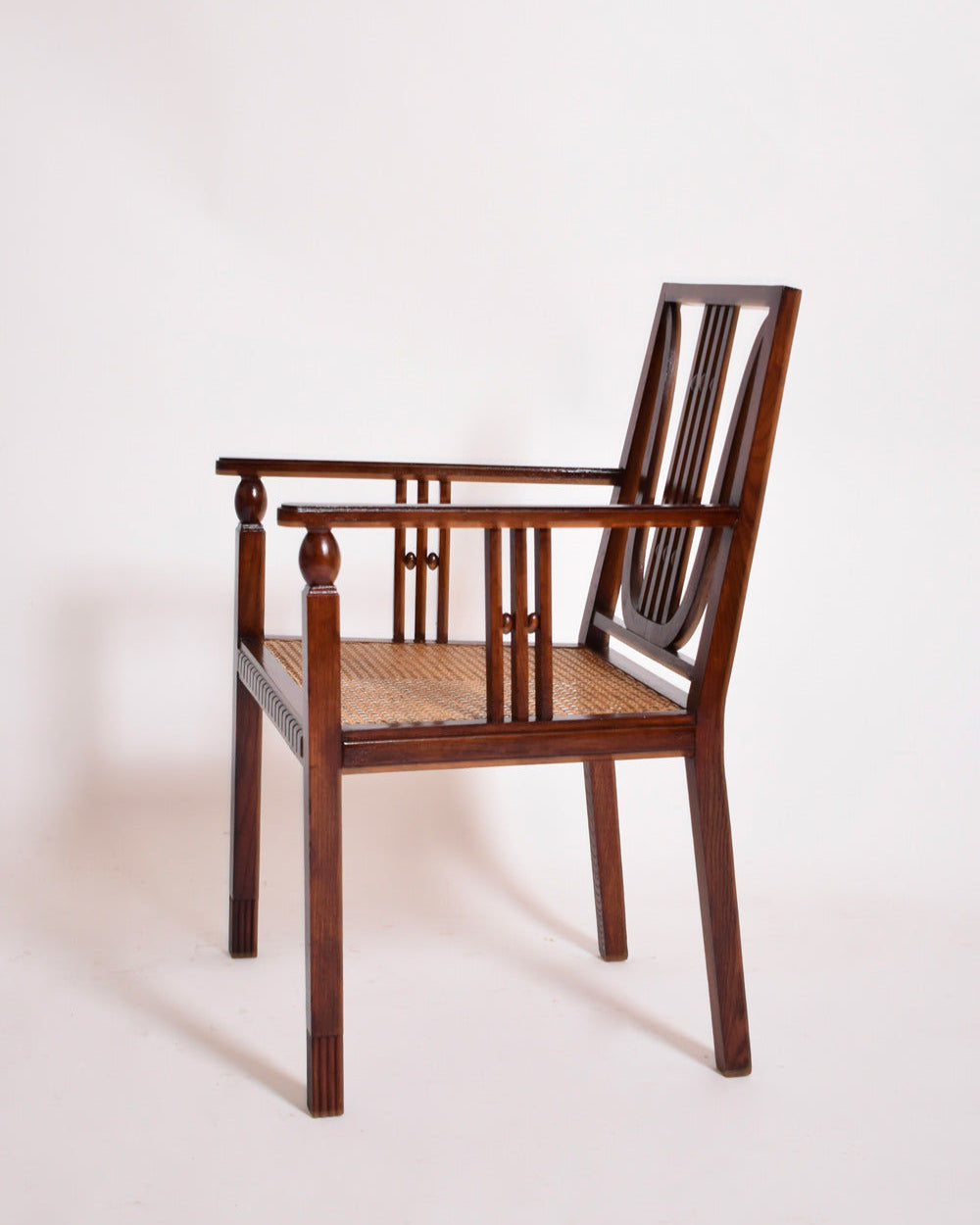 The Barracuda Interiors Viennese Secession Armchair, 1910s, features a cane seat, carved backrest, and straight legs, displayed against a plain white background.