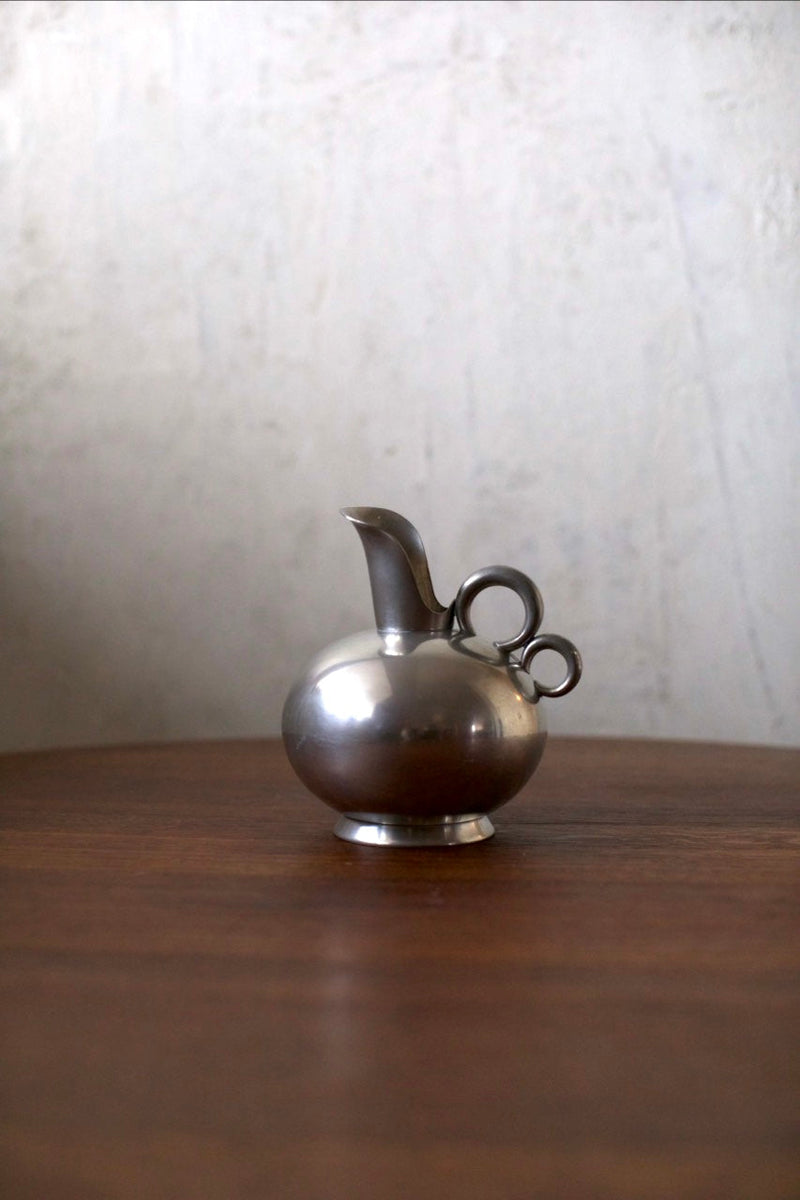 Tin Vase — close-up of polished metal surface on wooden table