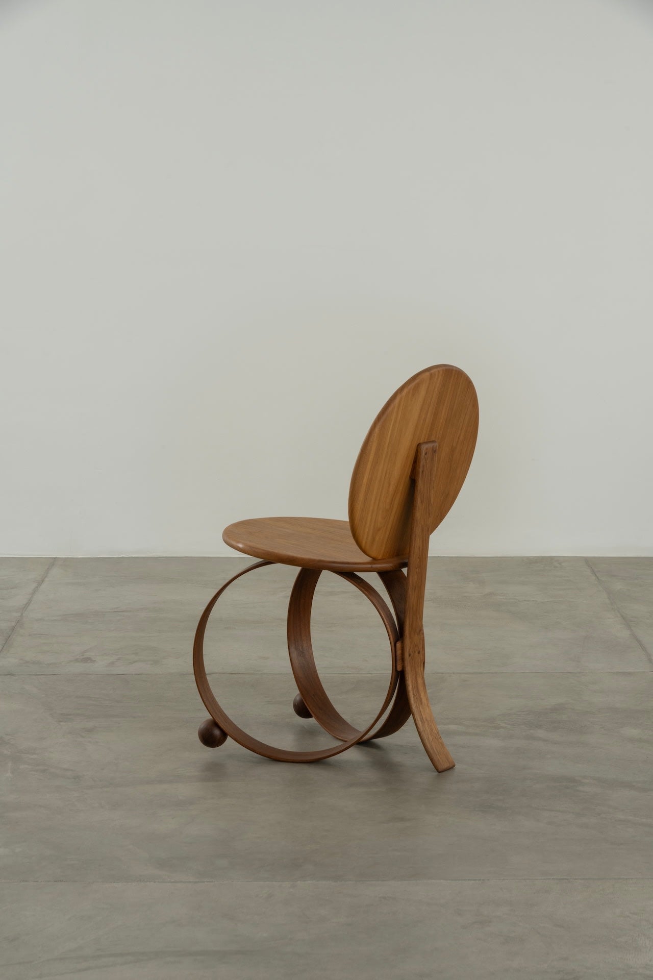 Yara' Chair — side angle showing wooden seat and circular base