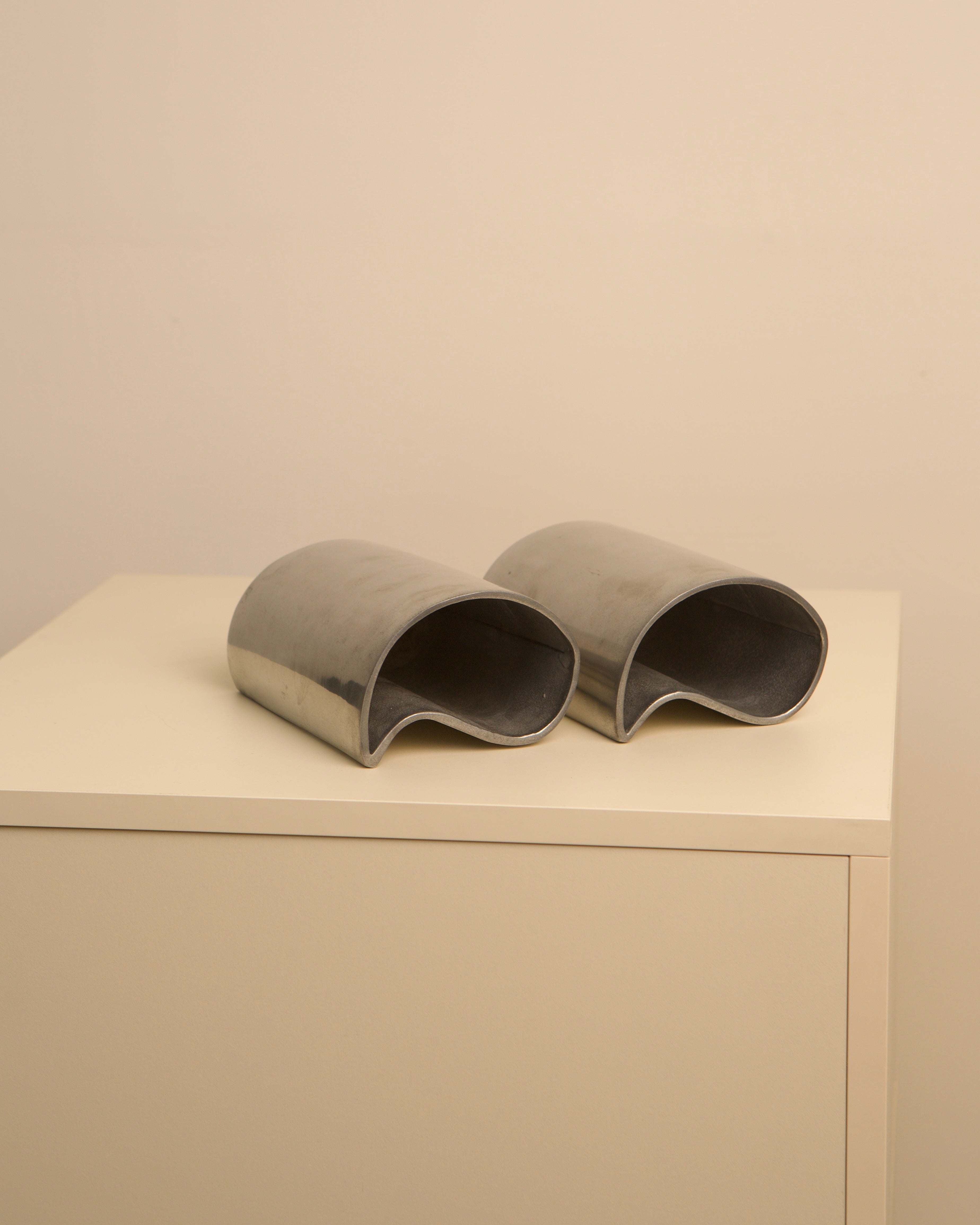 Pair of curved aluminum vases in sculptural yin yang design