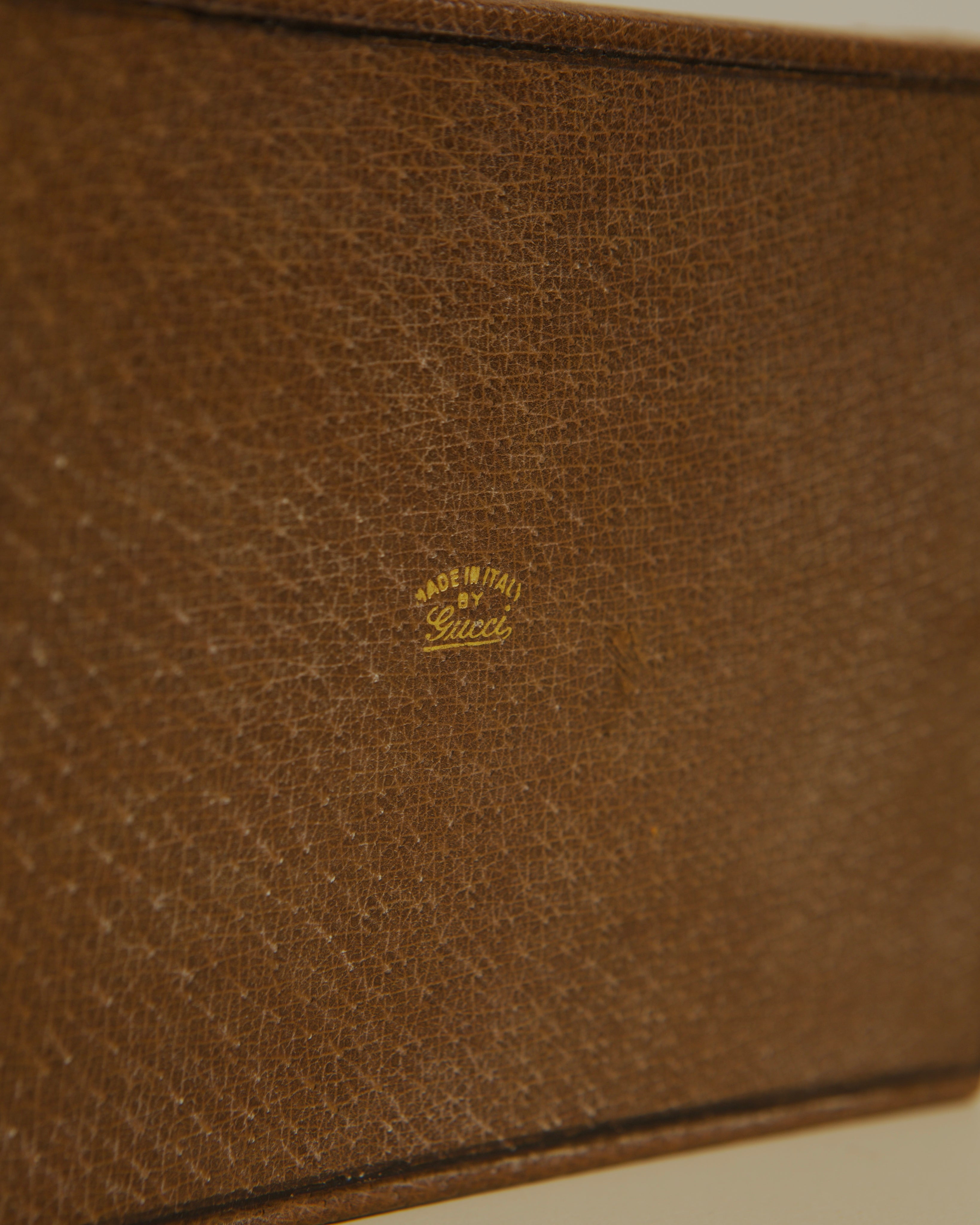 Close-up of Gucci leather stamp on brown vintage box surface