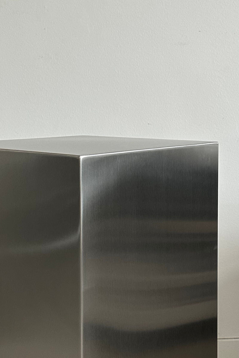 NOSTALGIA' stainless steel cube — close-up of polished metal surface