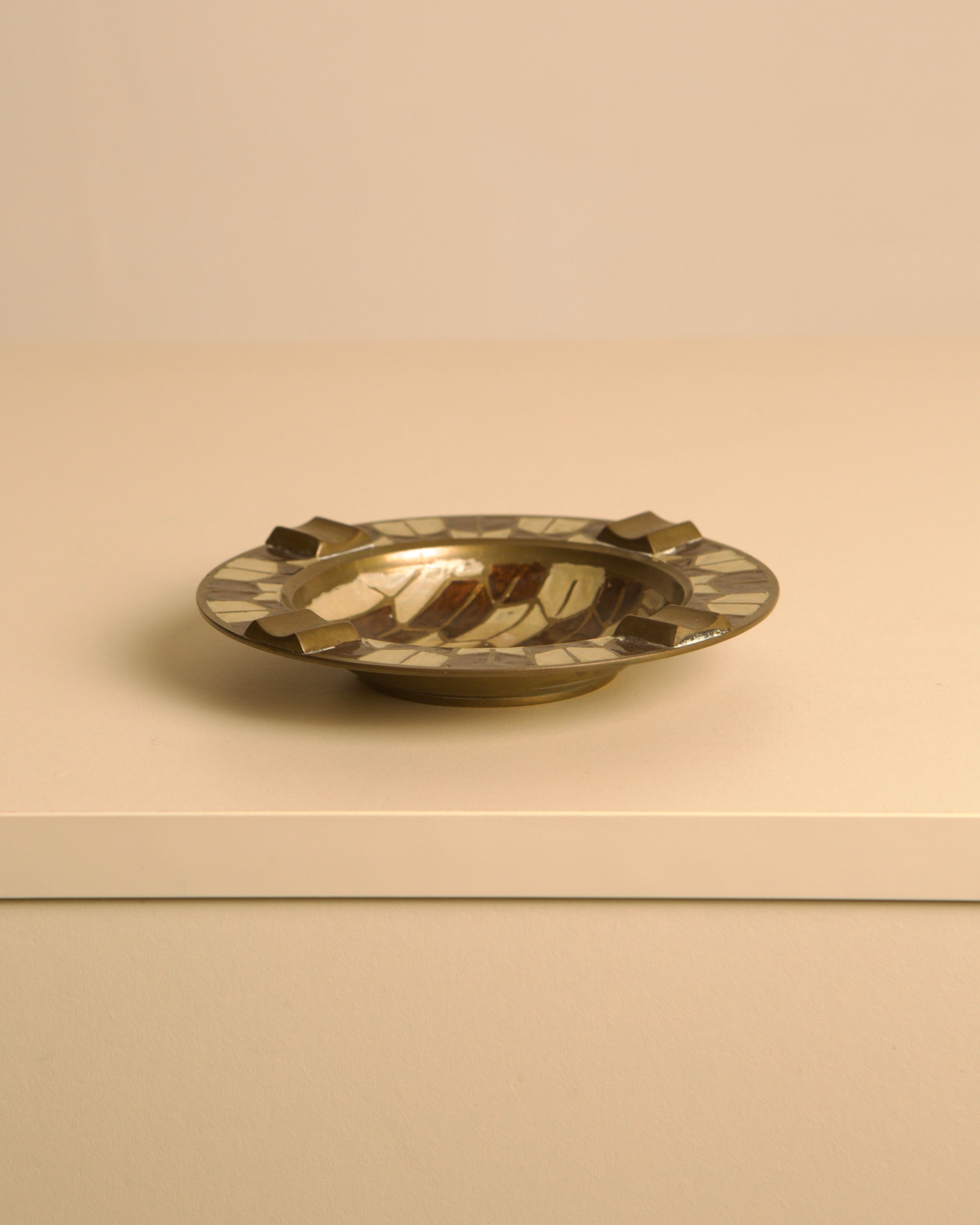 50's Brass Ashtray with Enameled Patterns — side angle on neutral background